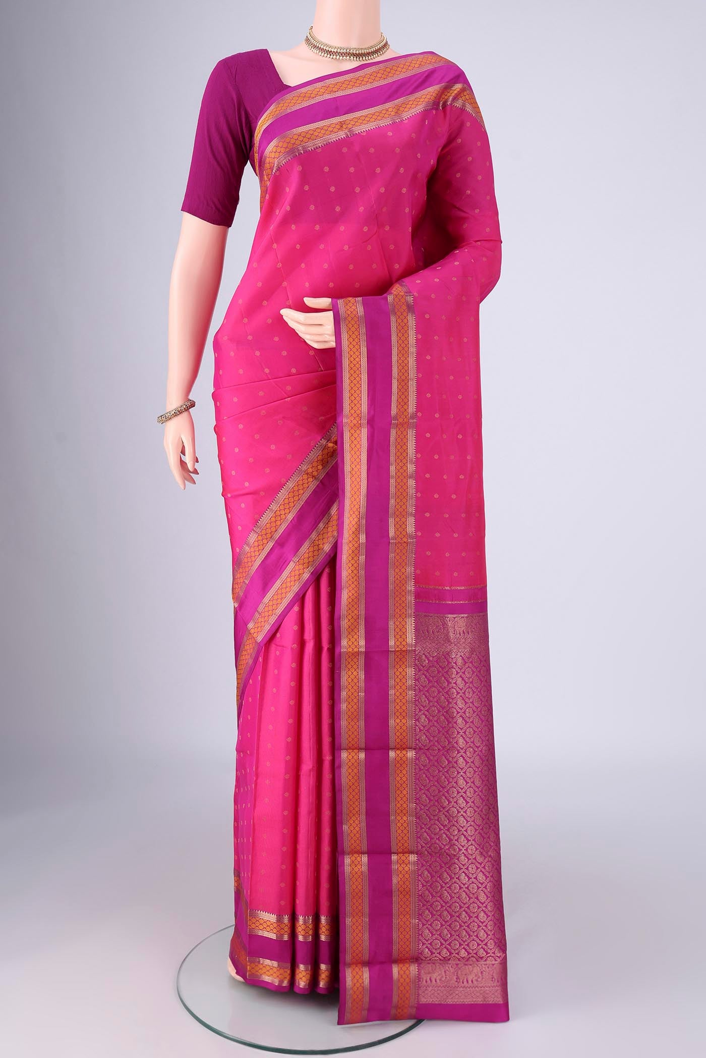 Dark Pink Kanchipuram Silk Saree with Zari Butta on the body and Zari Border.  displayed on a mannequin