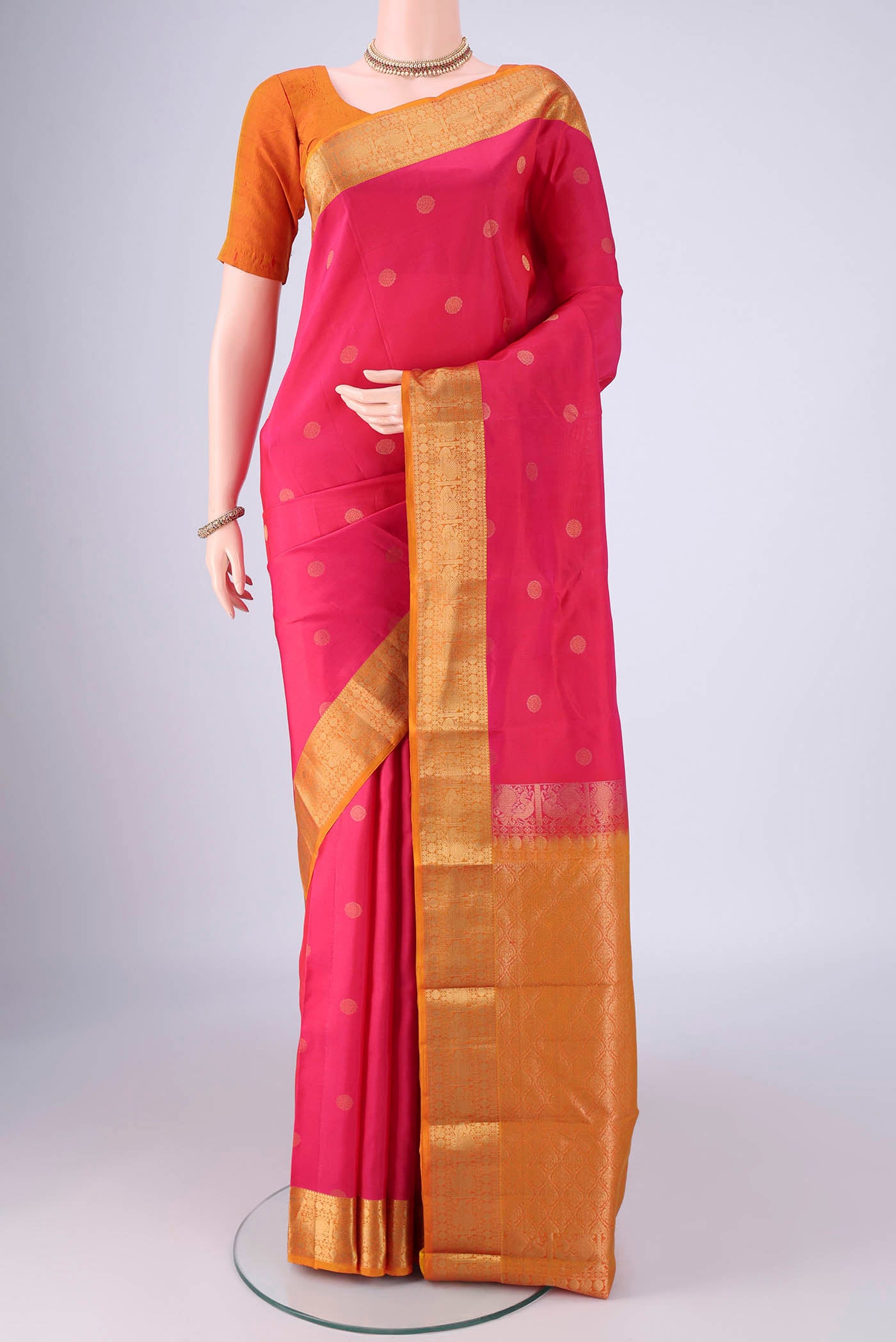 Pink Kanchipuram Silk Saree with Zari Butta on the body and Zari Border.  displayed on a mannequin