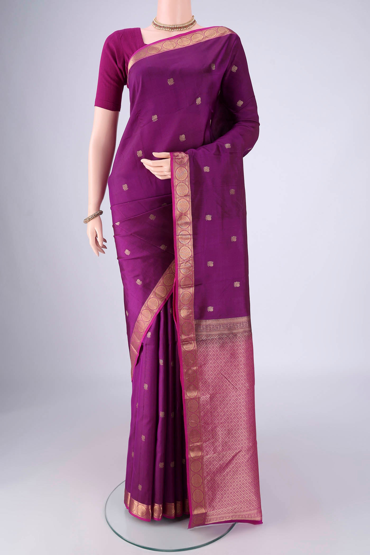 Purple Kanjivaram Silk Saree with Zari Butta on the body and Zari Border.  displayed on a mannequin