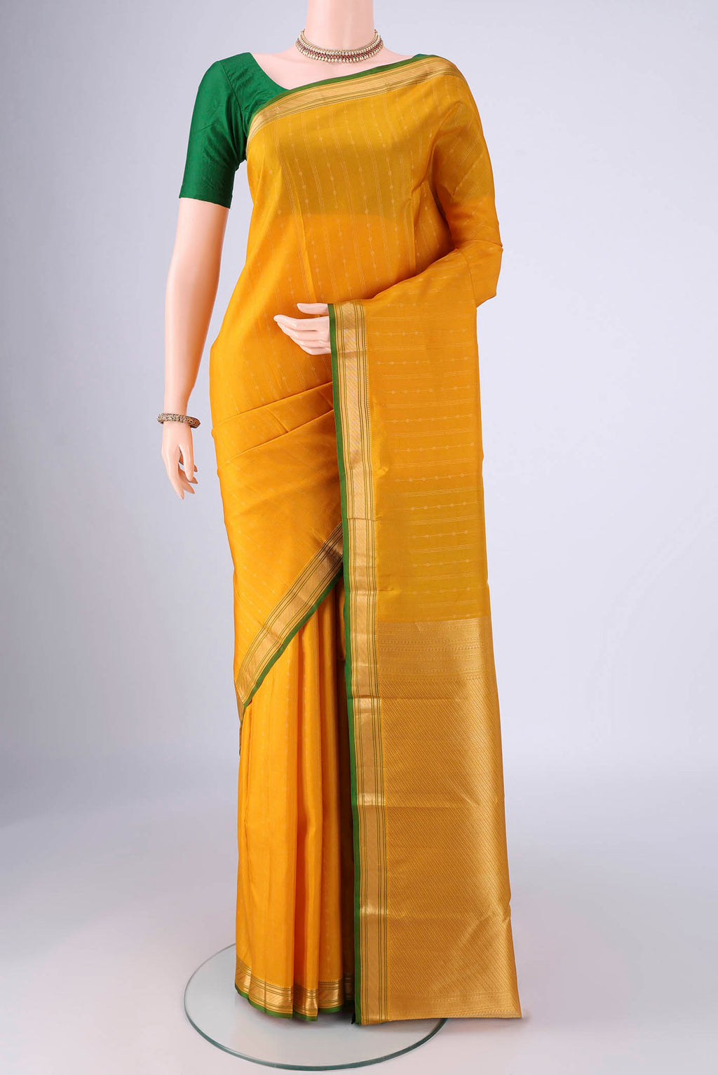 Yellow Kanchipuram Silk Saree with Zari Butta on the body and Zari Border.  displayed on a mannequin