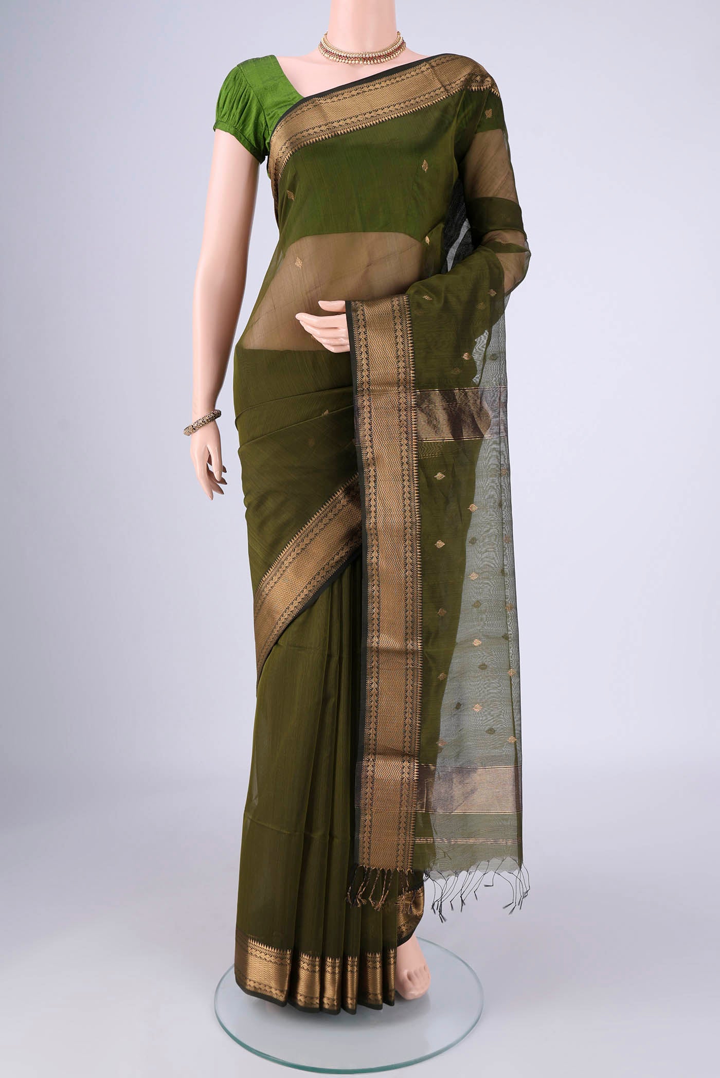 Mehandi Green Maheshwari Silk Cotton Saree with Zari Butta on the body and Zari Border.  displayed on a mannequin