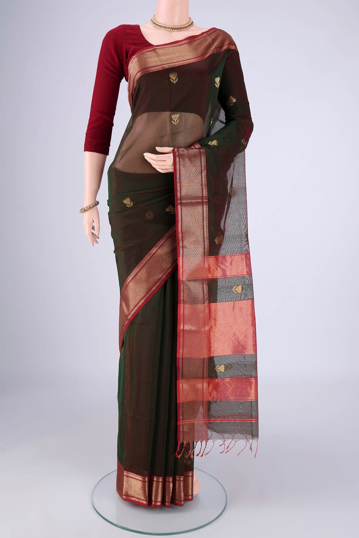 Bottle Green Dual Tone Maheshwari Silk Cotton Saree with Zari Butta on the body and Zari Border.  displayed on a mannequin