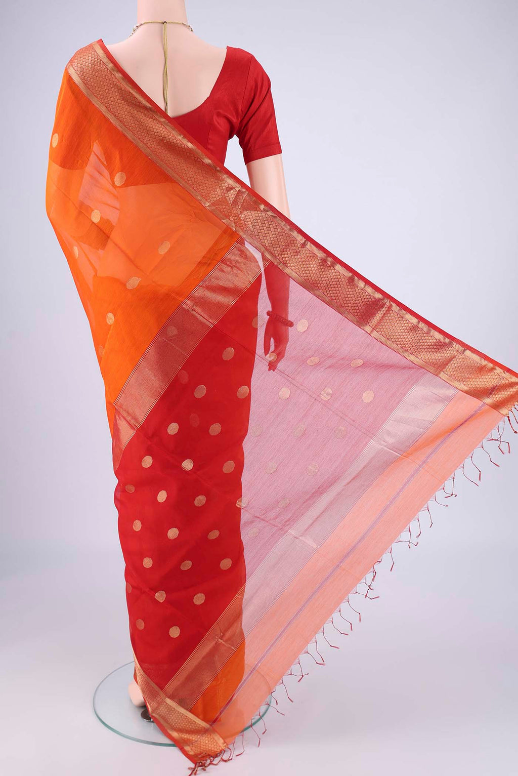 Flat view of Brick Orange Maheshwari Silk Cotton Saree with Zari Butta on the body and Zari Border. 