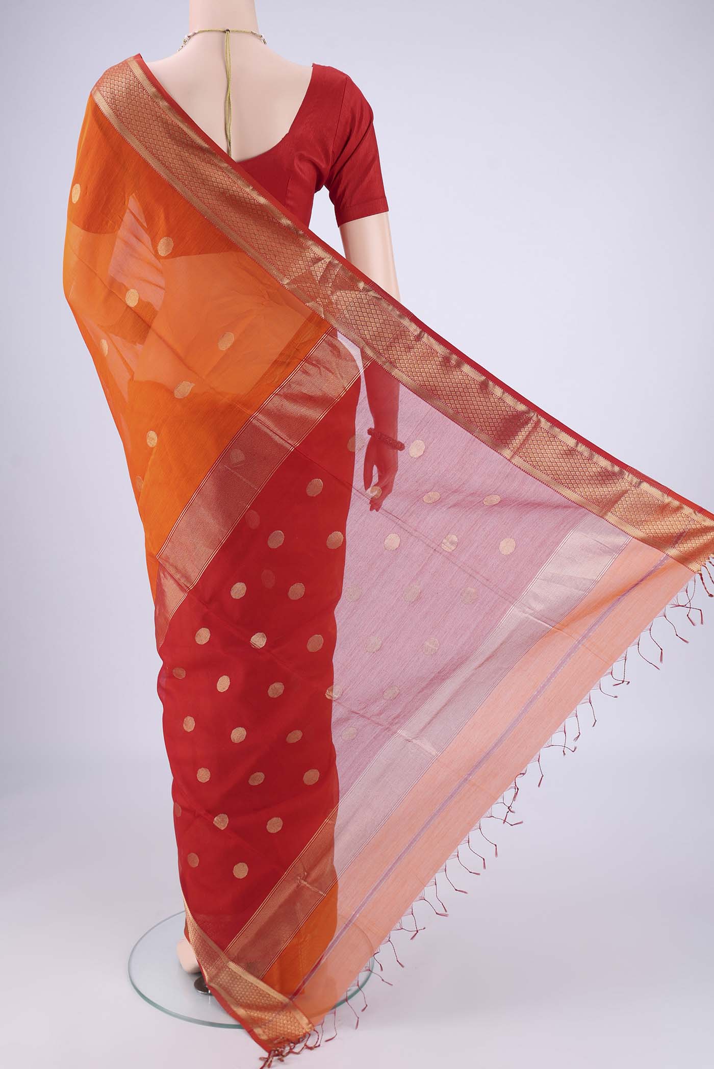 Flat view of Brick Orange Maheshwari Silk Cotton Saree with Zari Butta on the body and Zari Border. 