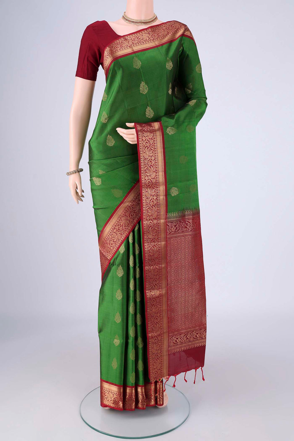 Green Soft Silk Saree with Zari Butta on the body and Zari Border.  displayed on a mannequin