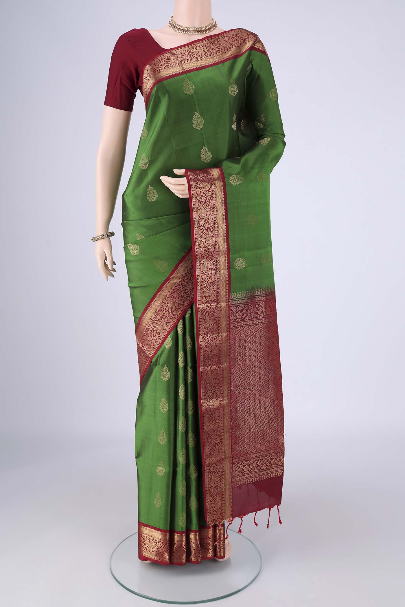 Green Soft Silk Saree with Zari Butta on the body and Zari Border.  displayed on a mannequin