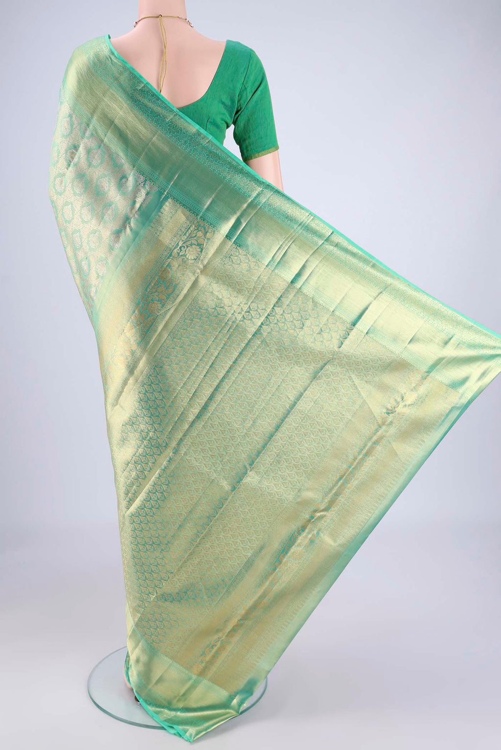Flat view of Sea Green Kanjivaram Tissue Silk Saree with Zari Brocade on the body and Zari Border. 