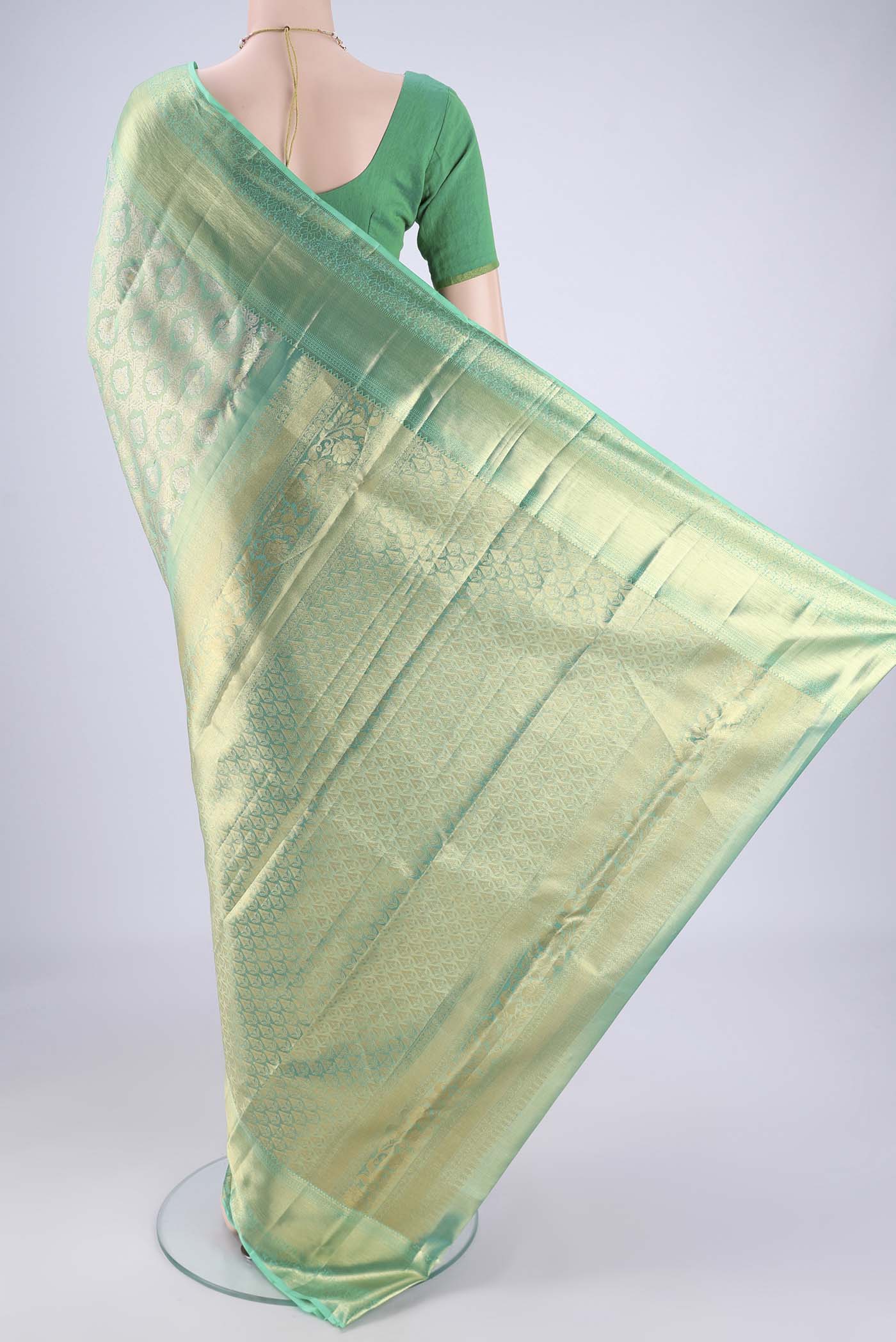 Flat view of Sea Green Kanjivaram Tissue Silk Saree with Zari Brocade on the body and Zari Border. 