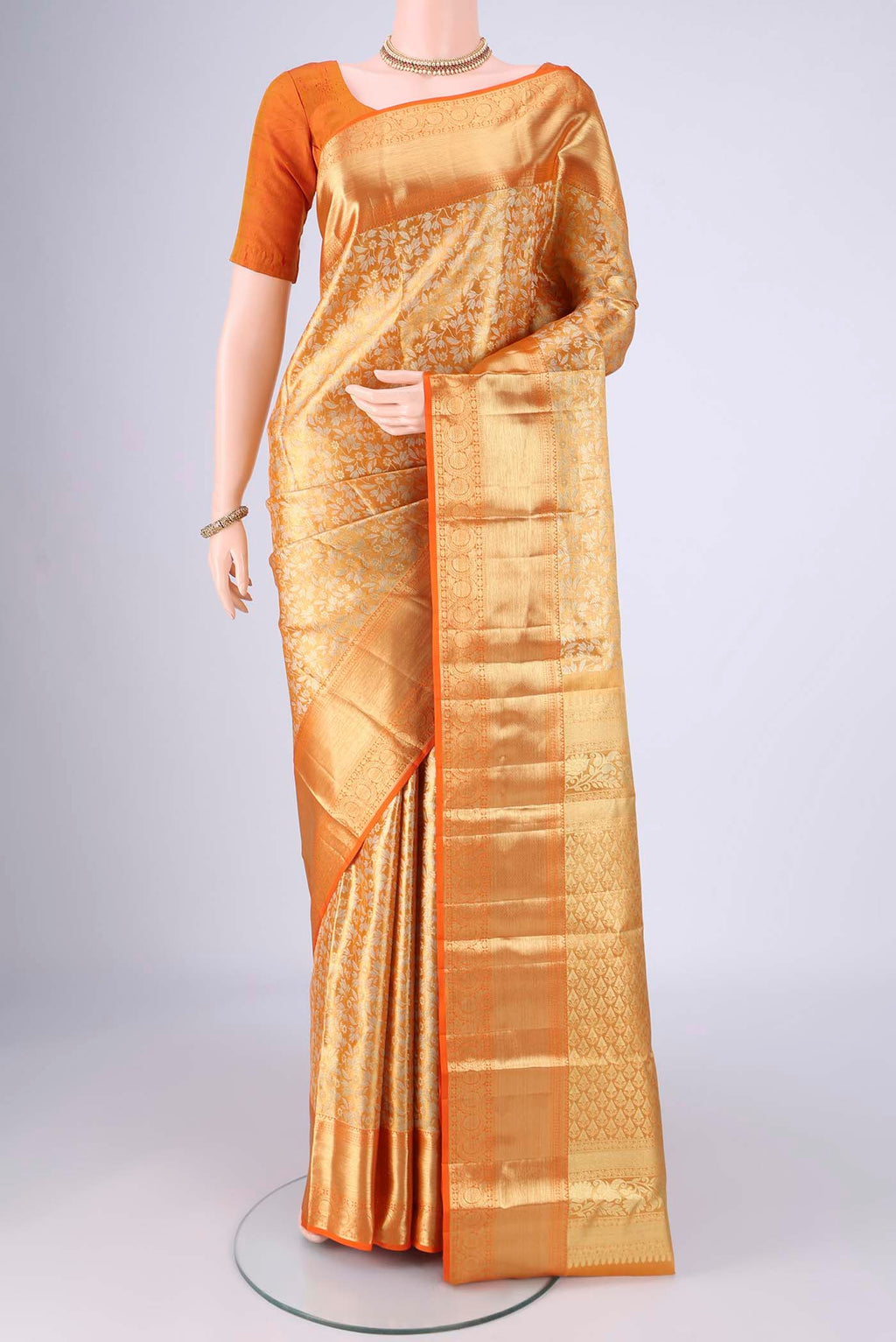 Golden Dual Tone Kanjivaram Tissue Silk Saree with Zari Brocade on the body and Zari Border.  displayed on a mannequin
