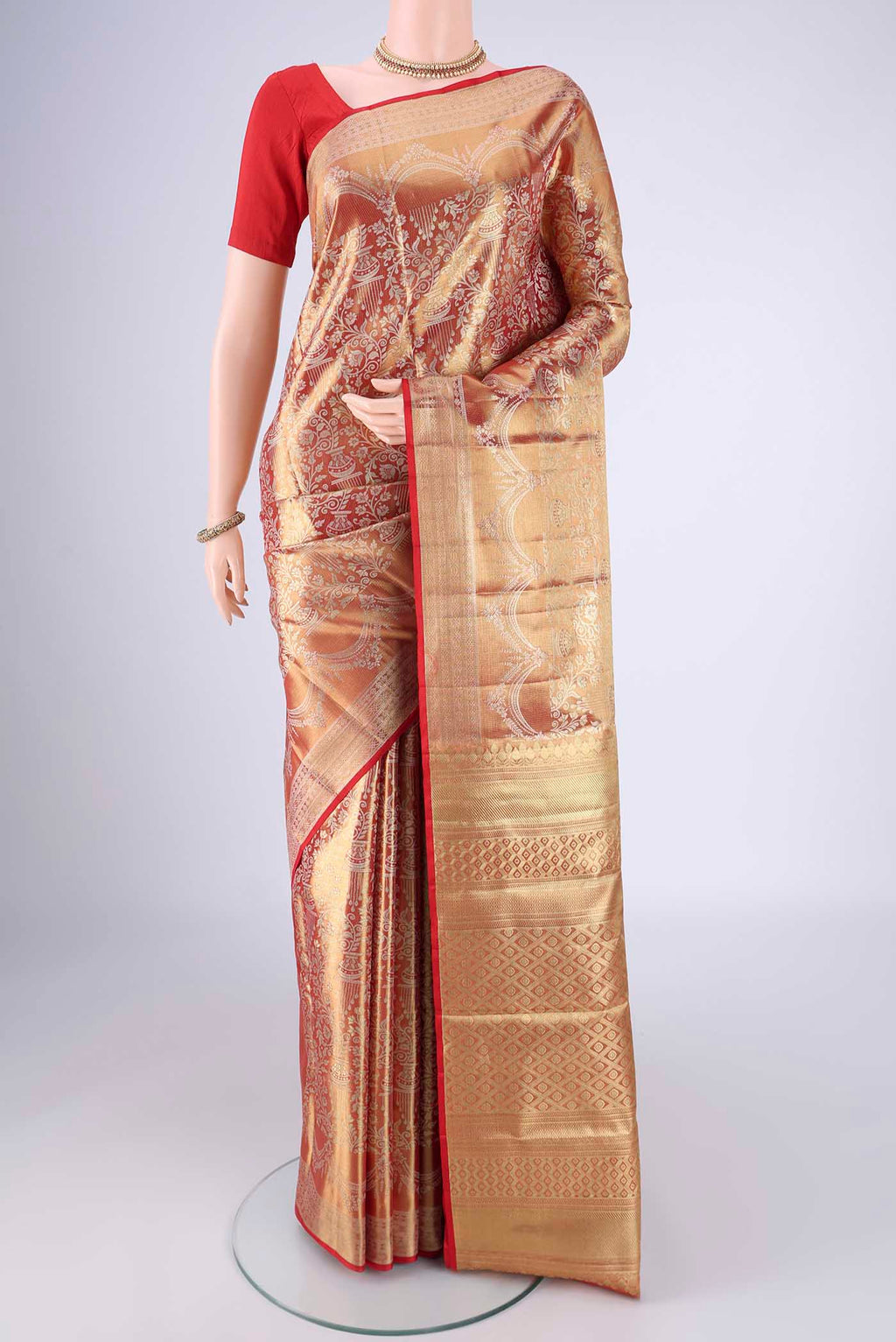 Gold with Red Color Kanjivaram Tissue Silk Saree with Zari Brocade on the body and Zari Border.  displayed on a mannequin