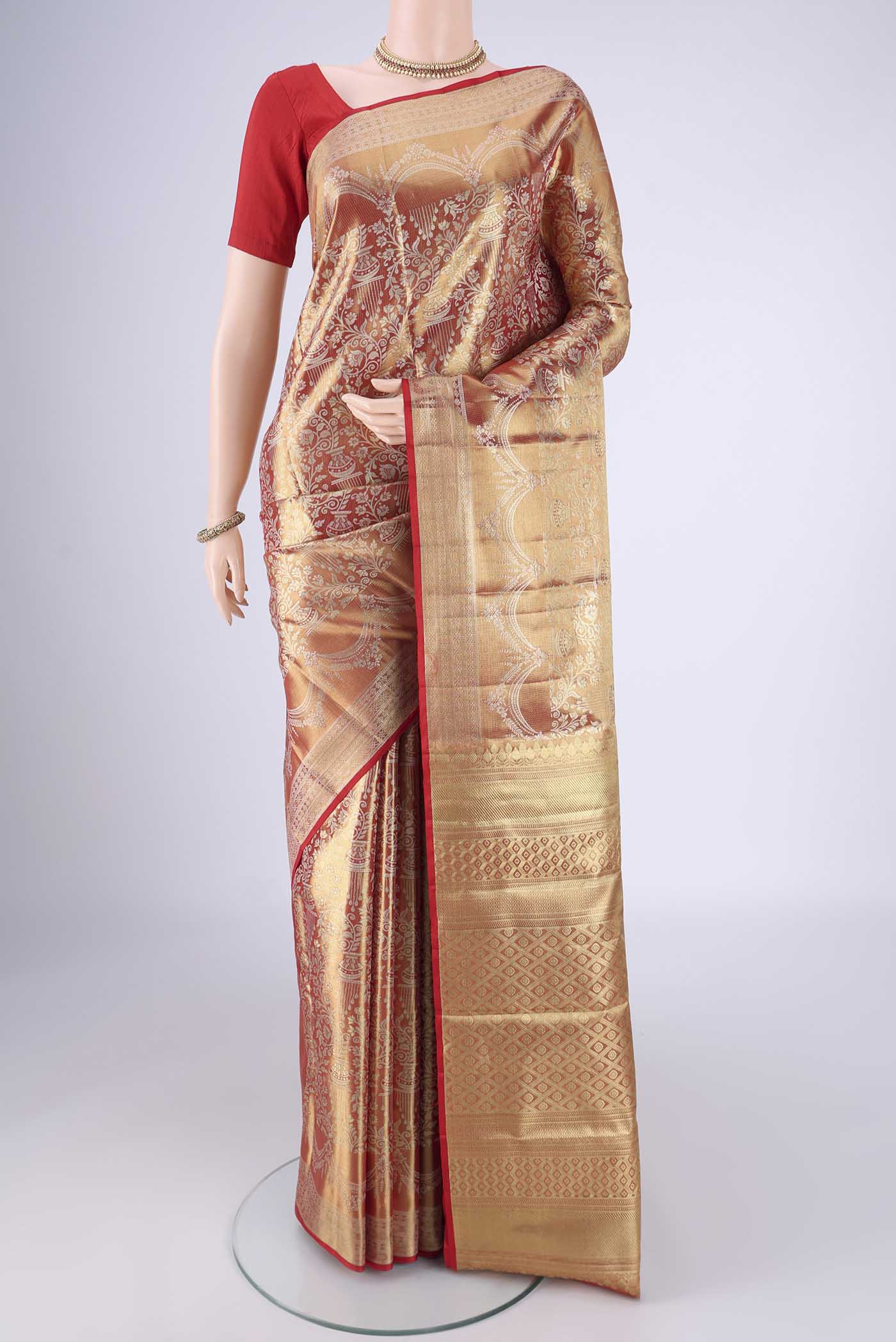 Gold with Red Color Kanjivaram Tissue Silk Saree with Zari Brocade on the body and Zari Border.  displayed on a mannequin