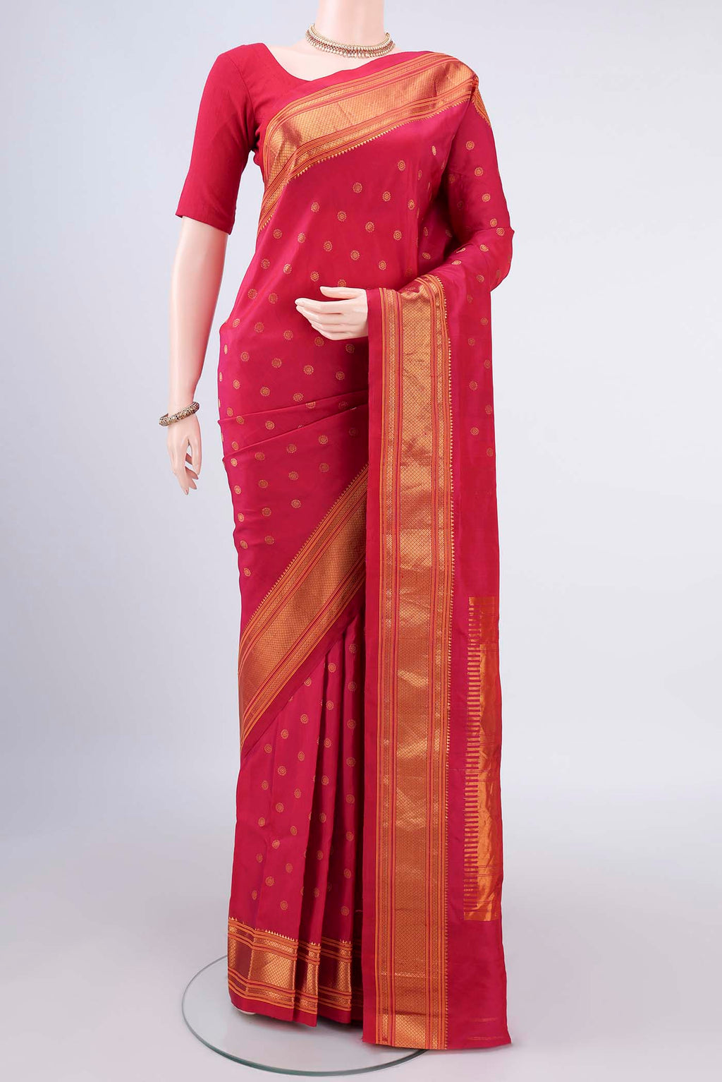 Pure Silk Coral Gadwal Saree with Zari Butta on the body and Zari Border.  displayed on a mannequin