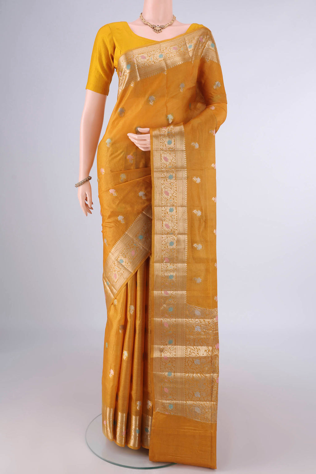 Mustard Banarasi Tussar Saree with Zari And Thread Butta on the body and Zari And Thread Border.  displayed on a mannequin