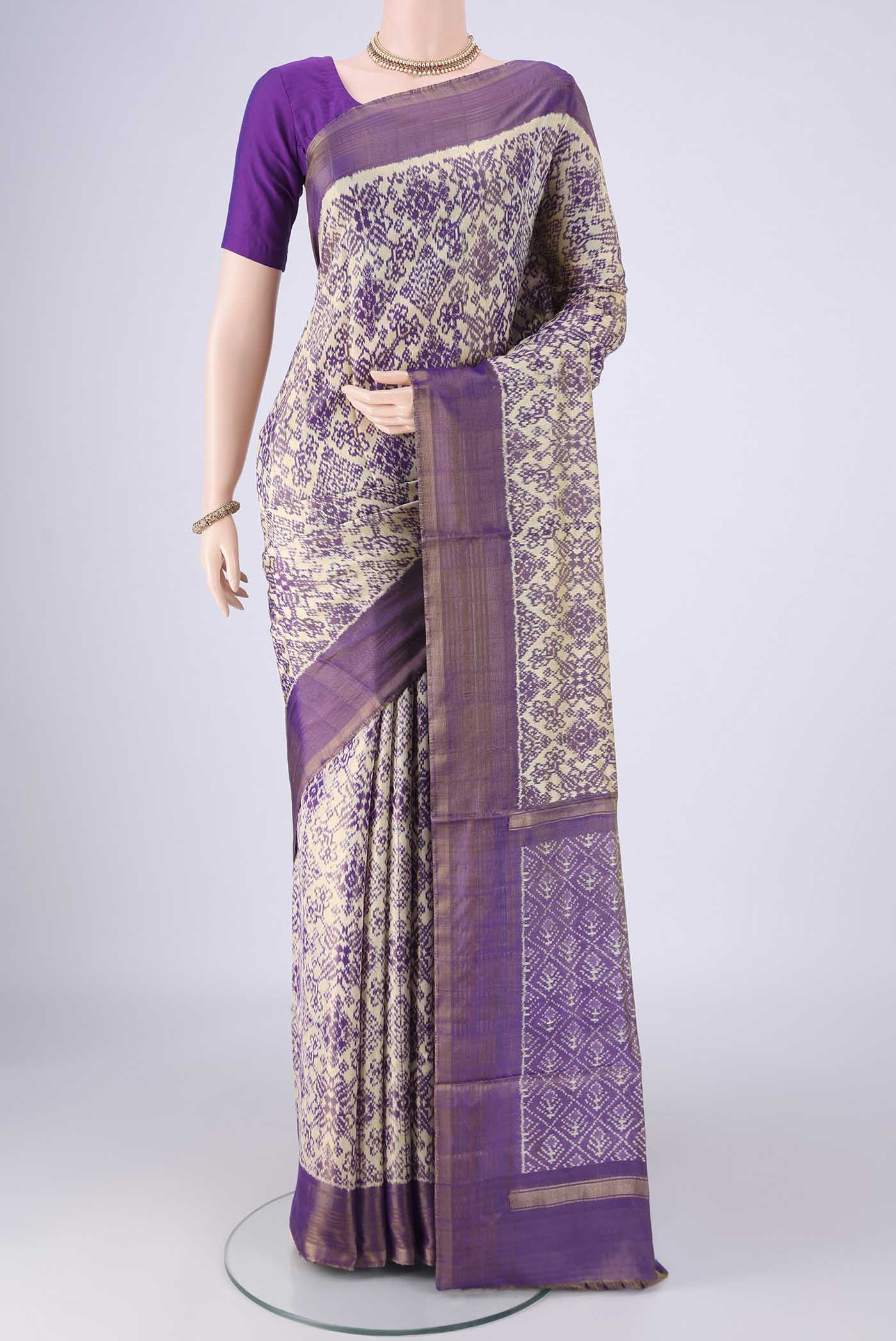 Off White Pochampally Silk Saree with Ikat design on the body and Zari Border.  displayed on a mannequin
