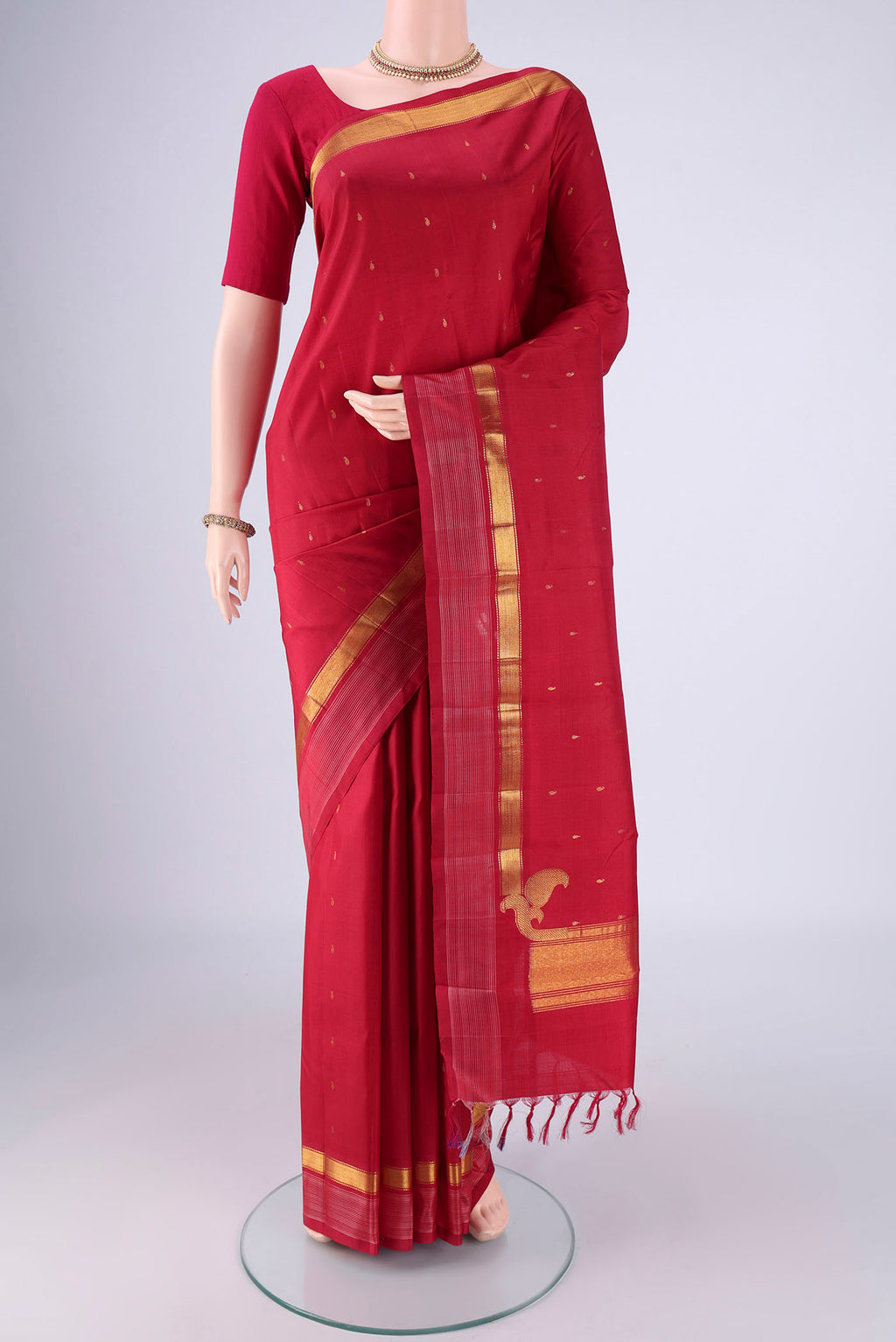 Red Kanchipuram Silk Saree with Zari Butta on the body and Zari Border.  displayed on a mannequin