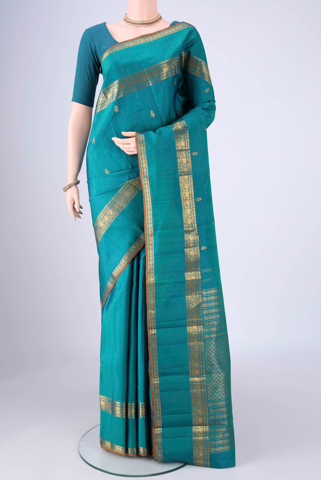 Sea Green Kanjivaram Silk Saree with Zari Butta on the body and Zari Border.  displayed on a mannequin
