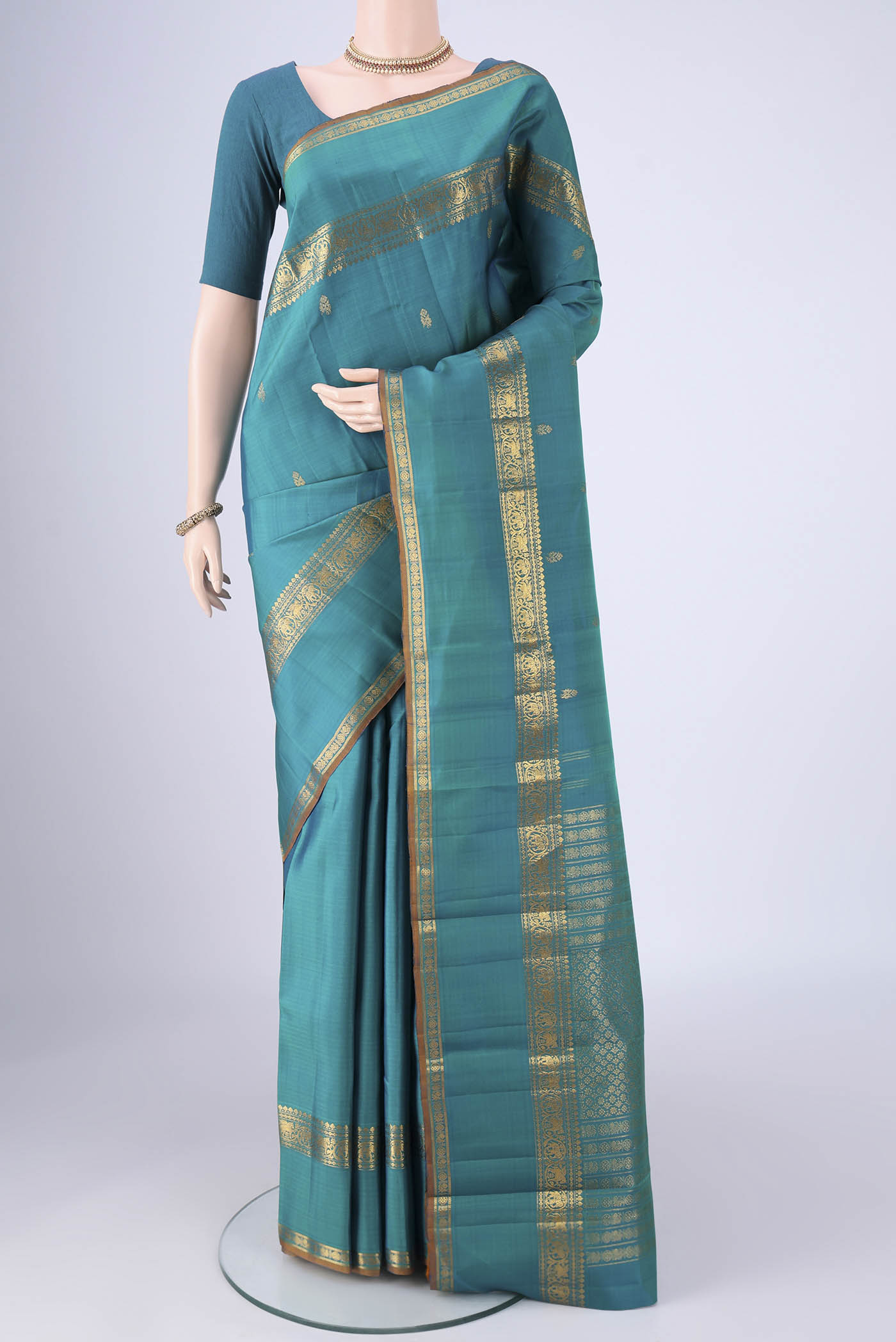 Sea Green Kanjivaram Silk Saree with Zari Butta on the body and Zari Border.  displayed on a mannequin