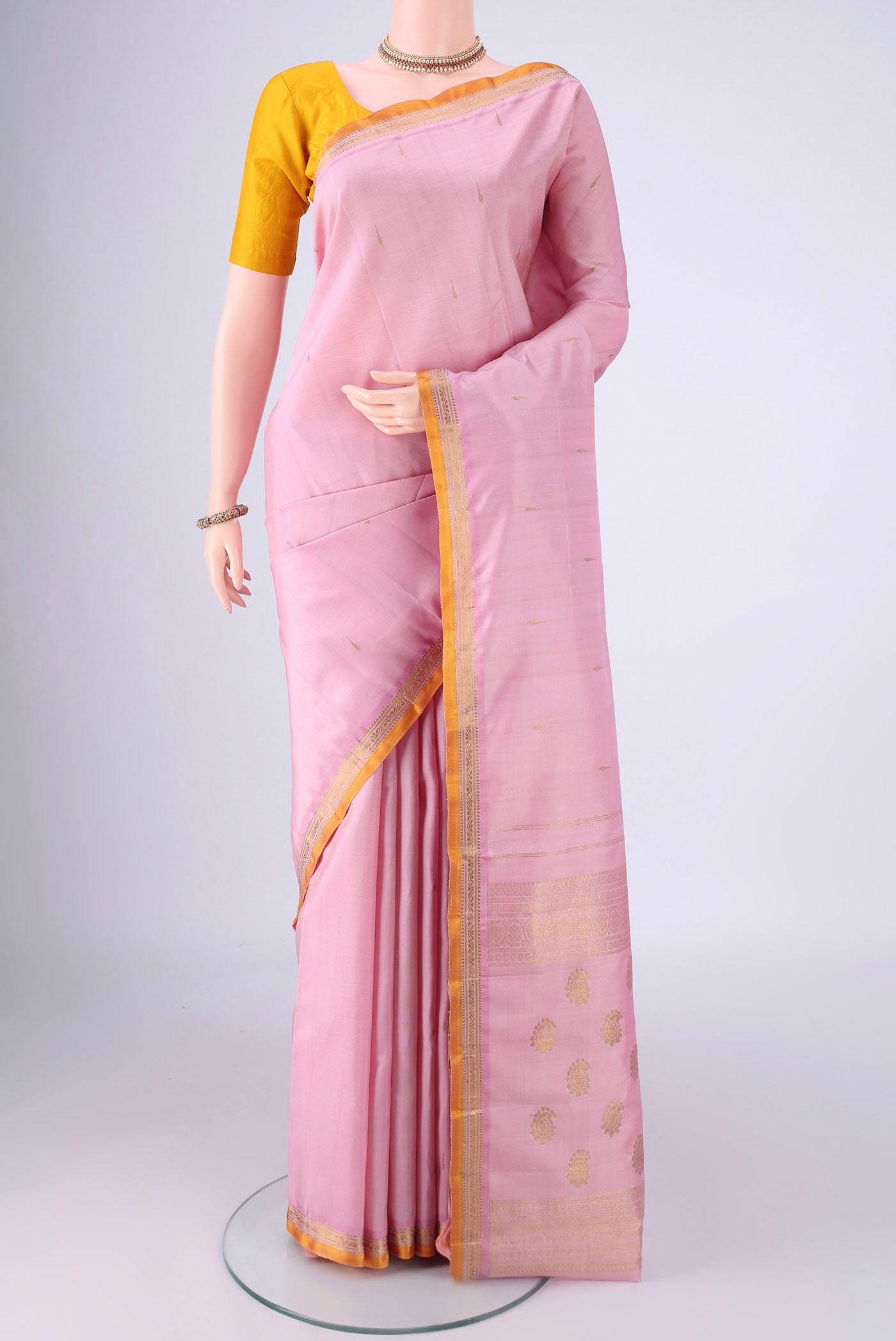 Rose pink Kanjivaram Silk Saree with Zari Butta on the body and Zari Border.  displayed on a mannequin
