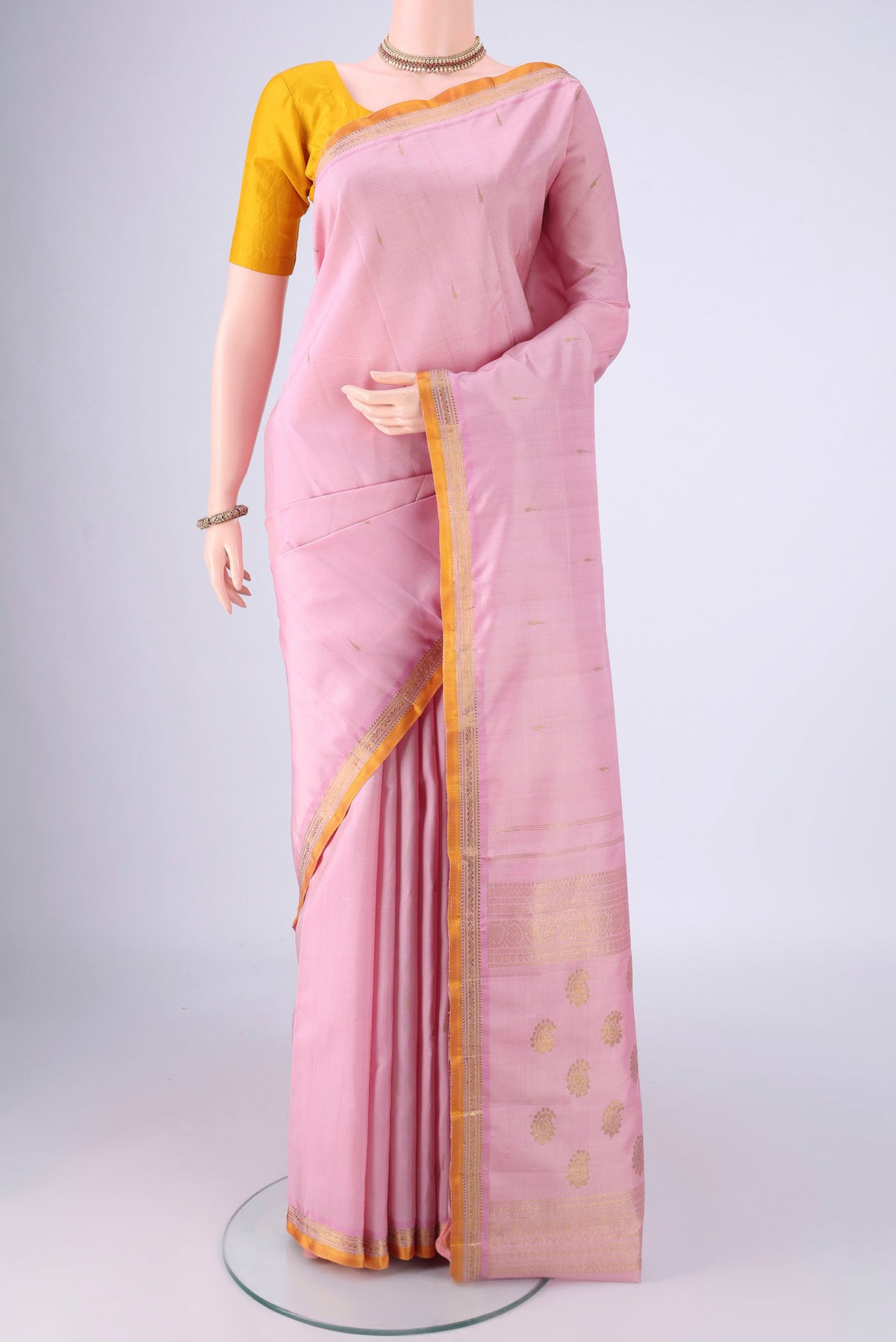 Rose pink Kanjivaram Silk Saree with Zari Butta on the body and Zari Border.  displayed on a mannequin
