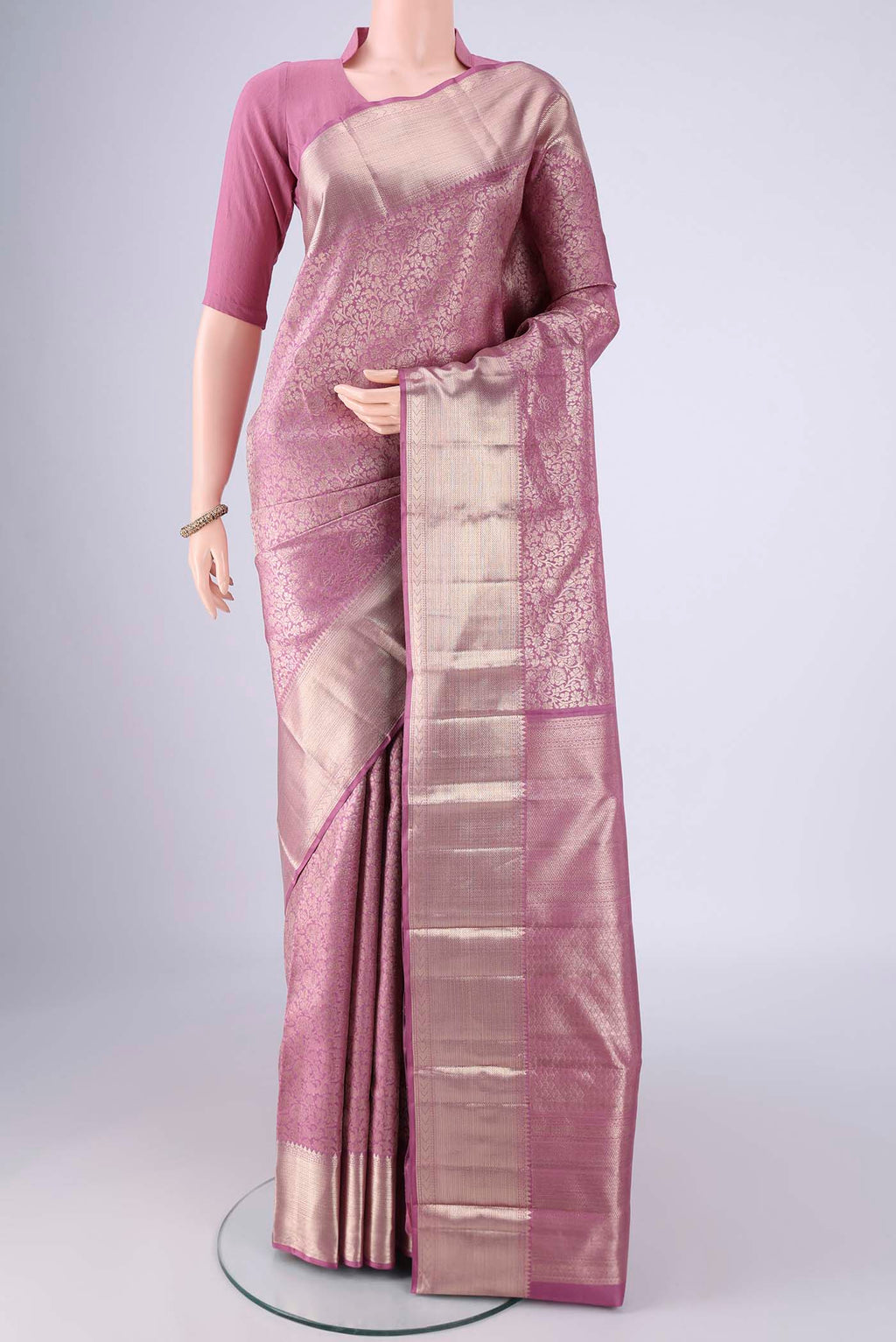 Mauve Kanchipuram Silk Saree with Zari Brocade on the body and Zari Border.  displayed on a mannequin