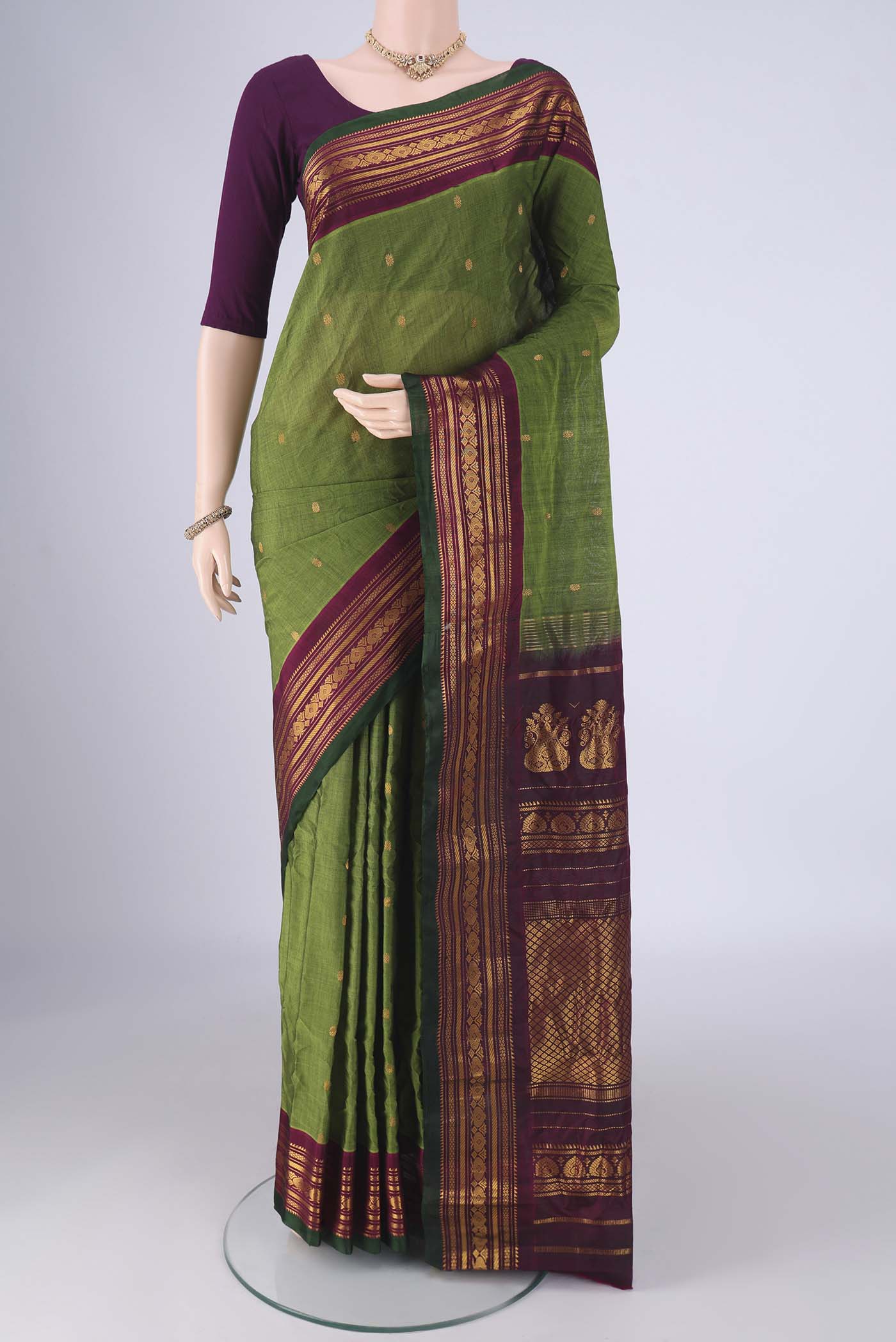 Green Gadwal Silk Cotton Saree with Zari Butta on the body and Zari Border.  displayed on a mannequin