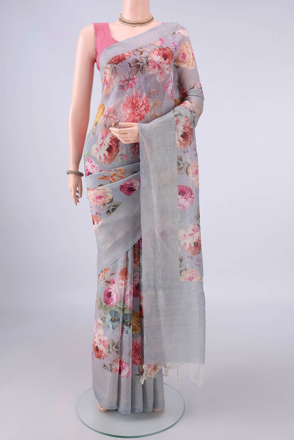 Grey Linen Saree with Floral Print on the body and Zari Border.  displayed on a mannequin