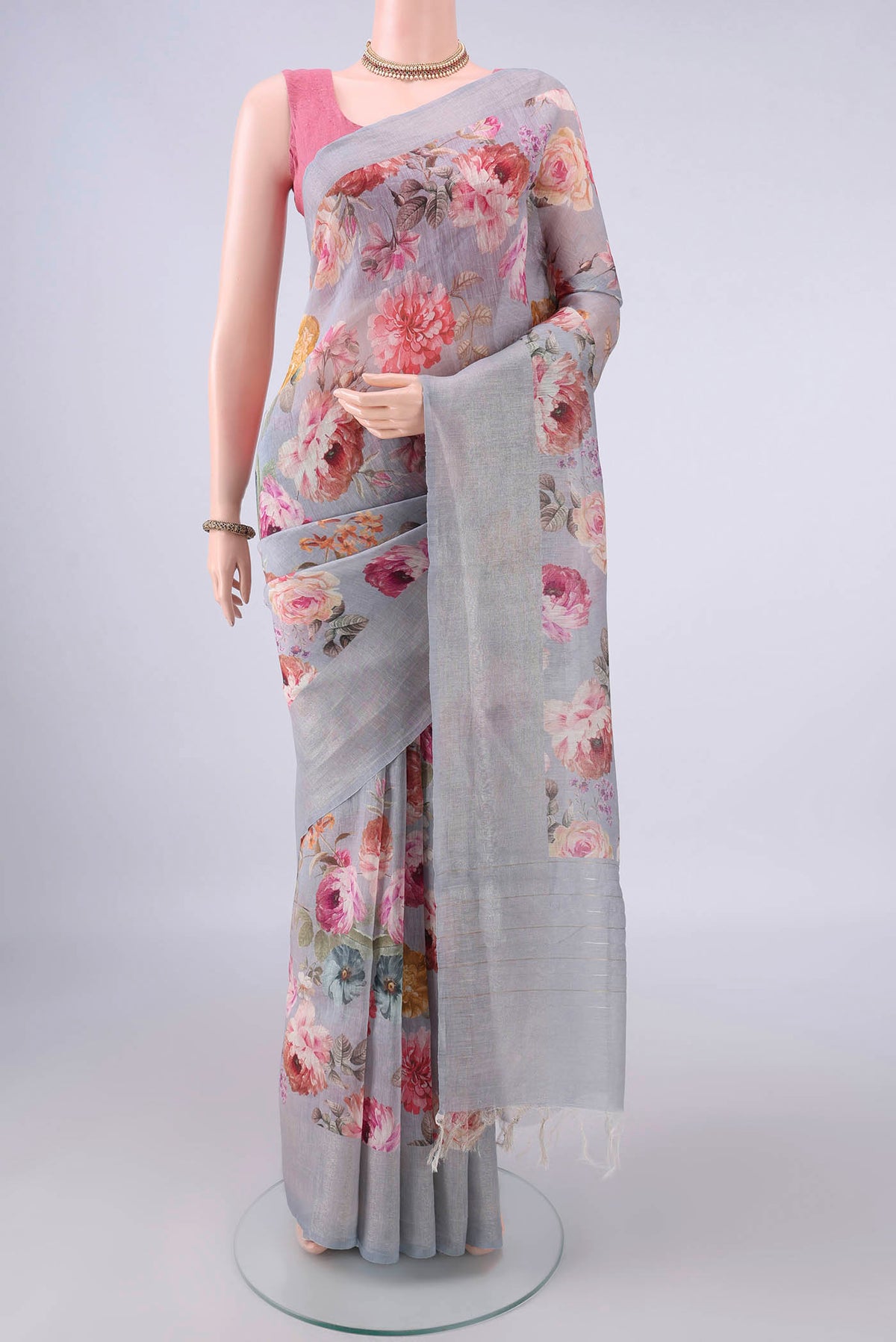 Grey Linen Saree with Floral Print on the body and Zari Border.  displayed on a mannequin
