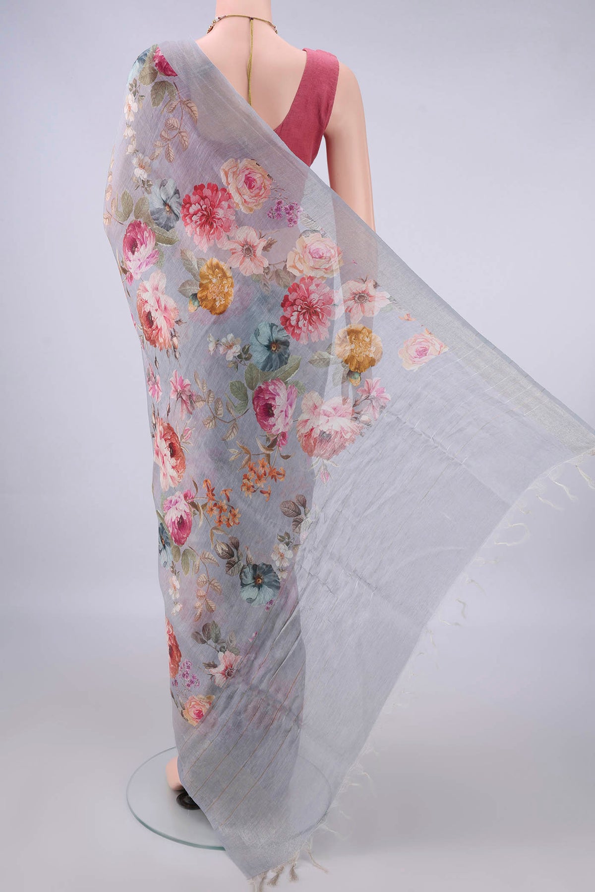 Flat view of Grey Linen Saree with Floral Print on the body and Zari Border. 