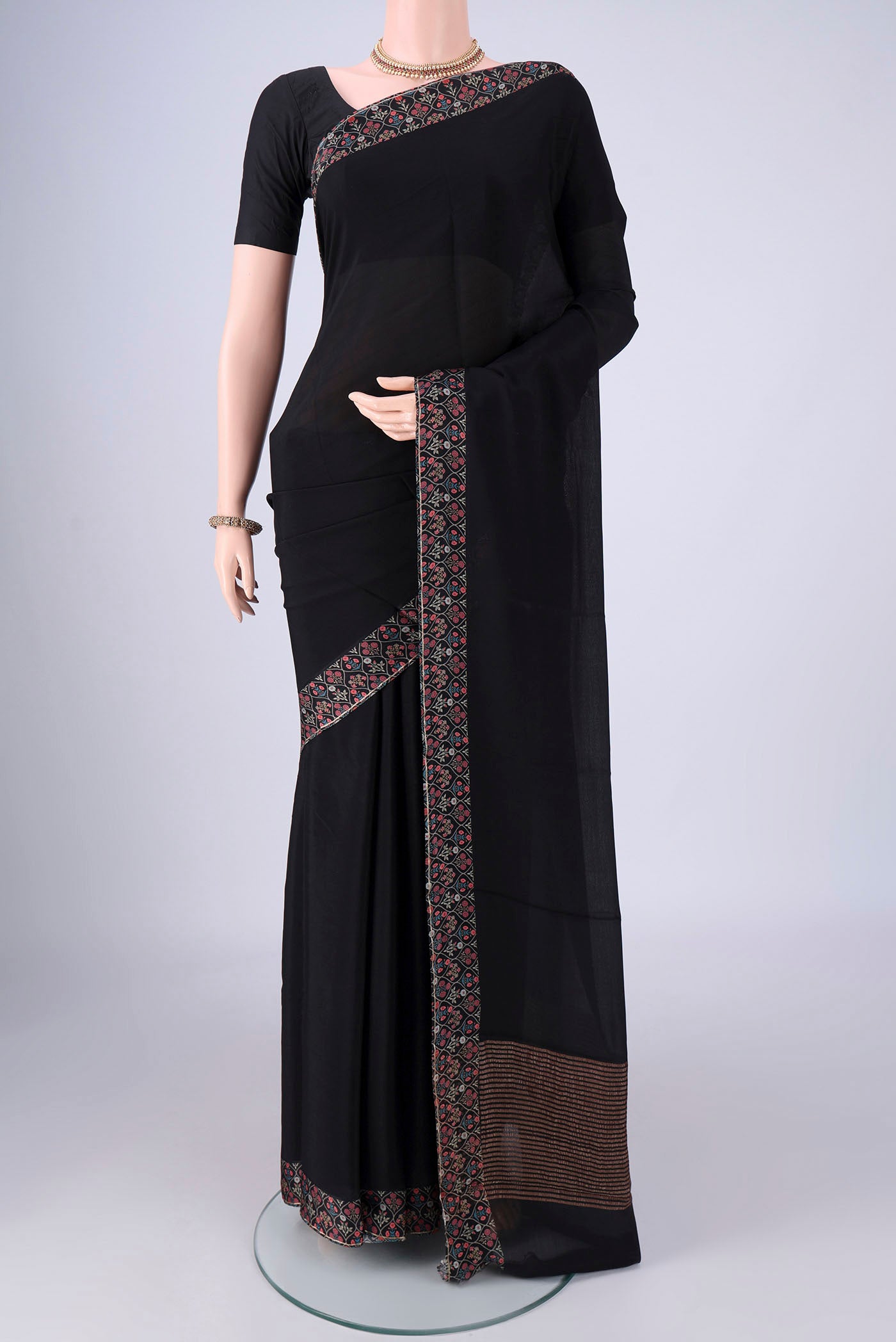Black Mysore Crepe Saree with Plain Body and Printed Border.  displayed on a mannequin