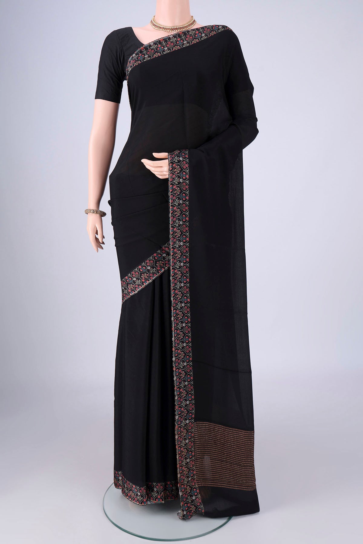Black Mysore Crepe Saree with Plain Body and Printed Border.  displayed on a mannequin
