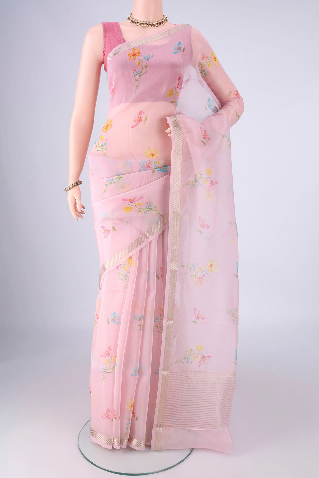 Rose pink Organza Silk Saree with Printed design on the body and Zari Border.  displayed on a mannequin