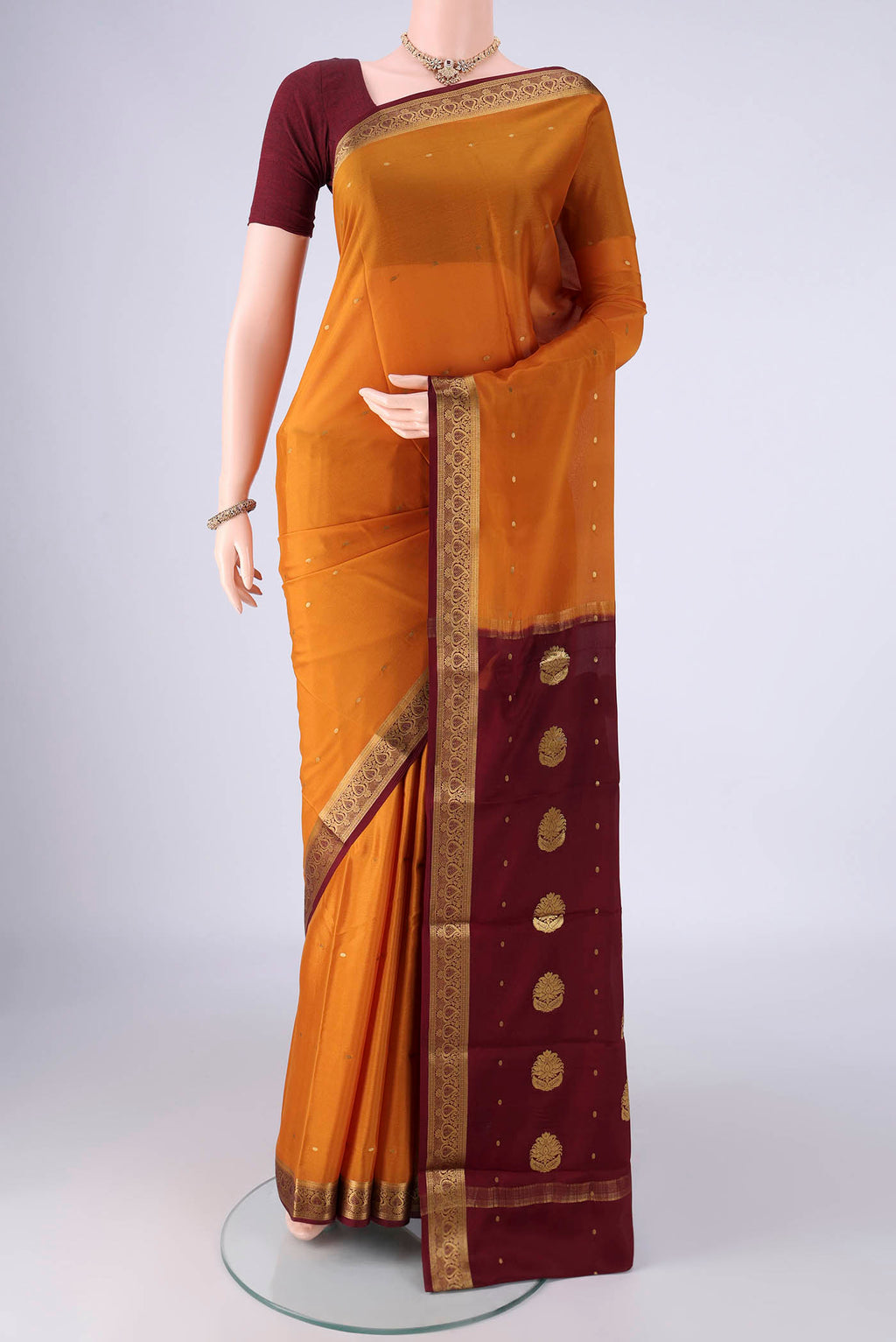 Mustard Mysore Crepe Saree with Zari Butta on the body and Zari Border.  displayed on a mannequin