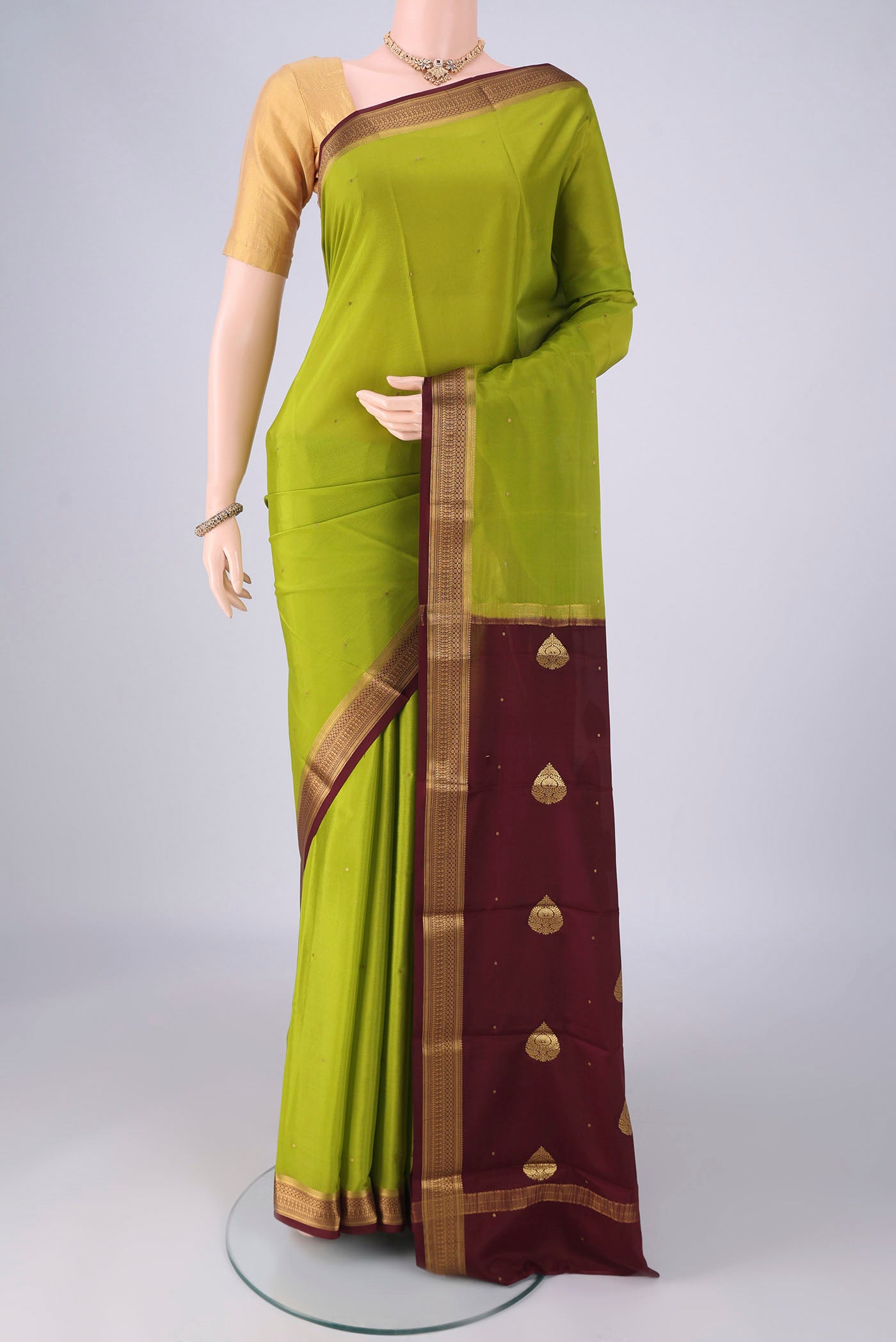 Acid Green Mysore Crepe Saree with Zari Butta on the body and Zari Border.  displayed on a mannequin