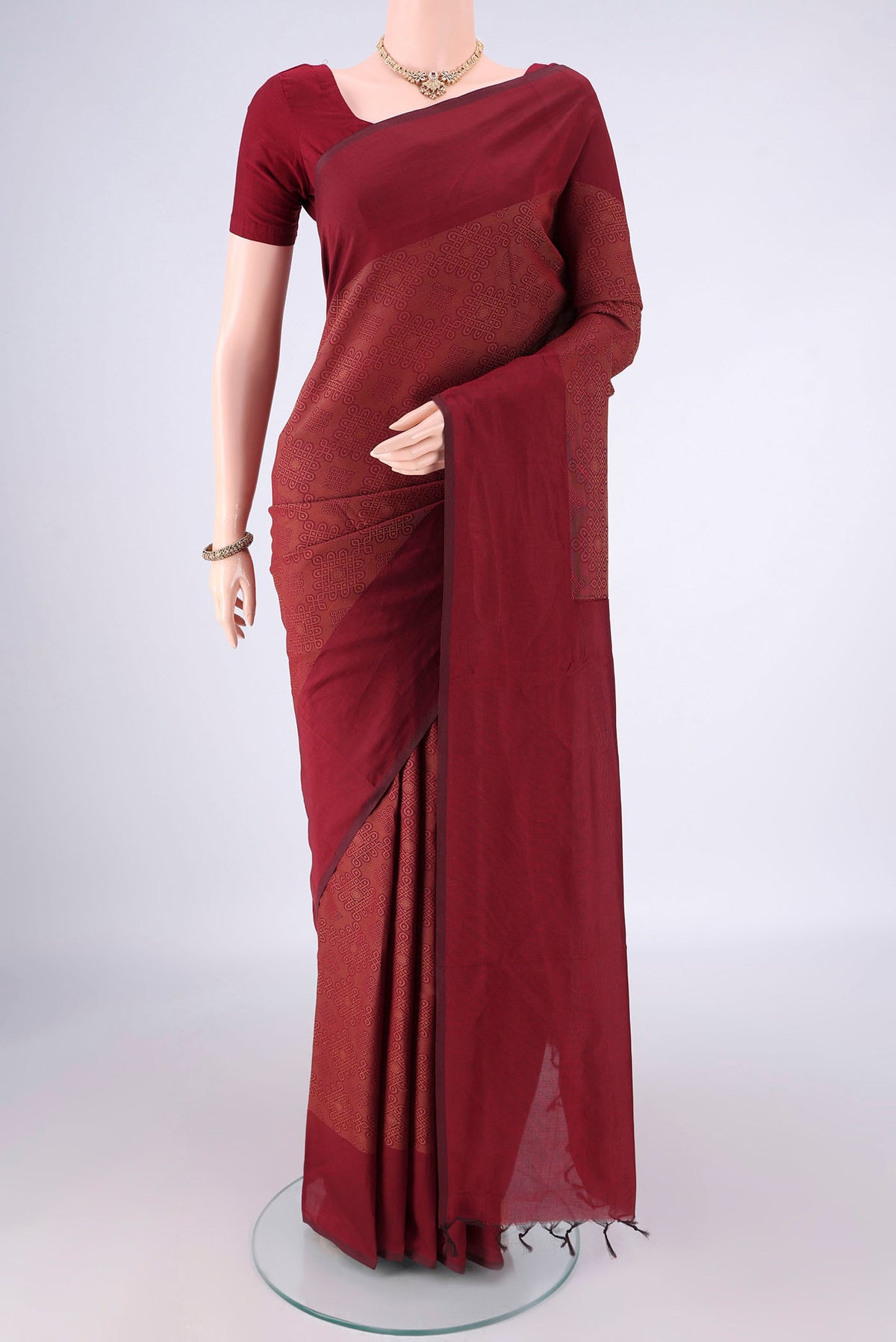 Maroon Blended Poly Cotton Saree with Jacquard design on the body and Thread Border.  displayed on a mannequin