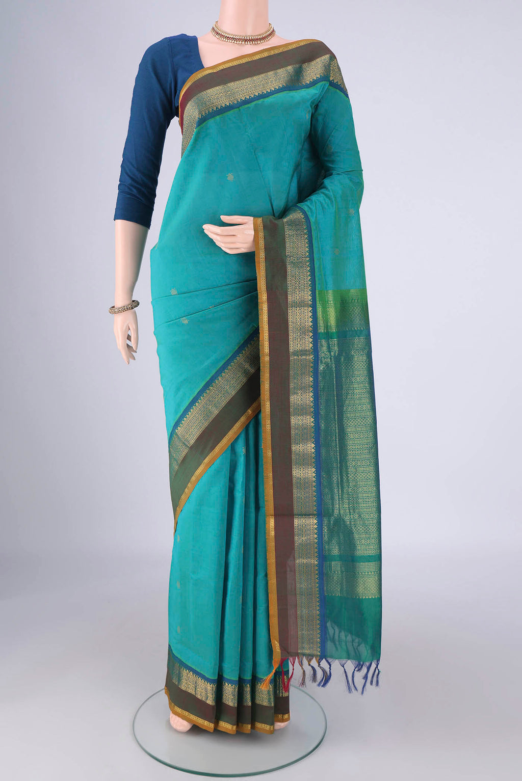 Sea Green Coimbatore Silk Cotton Saree with Zari Butta on the body and Zari Border.  displayed on a mannequin