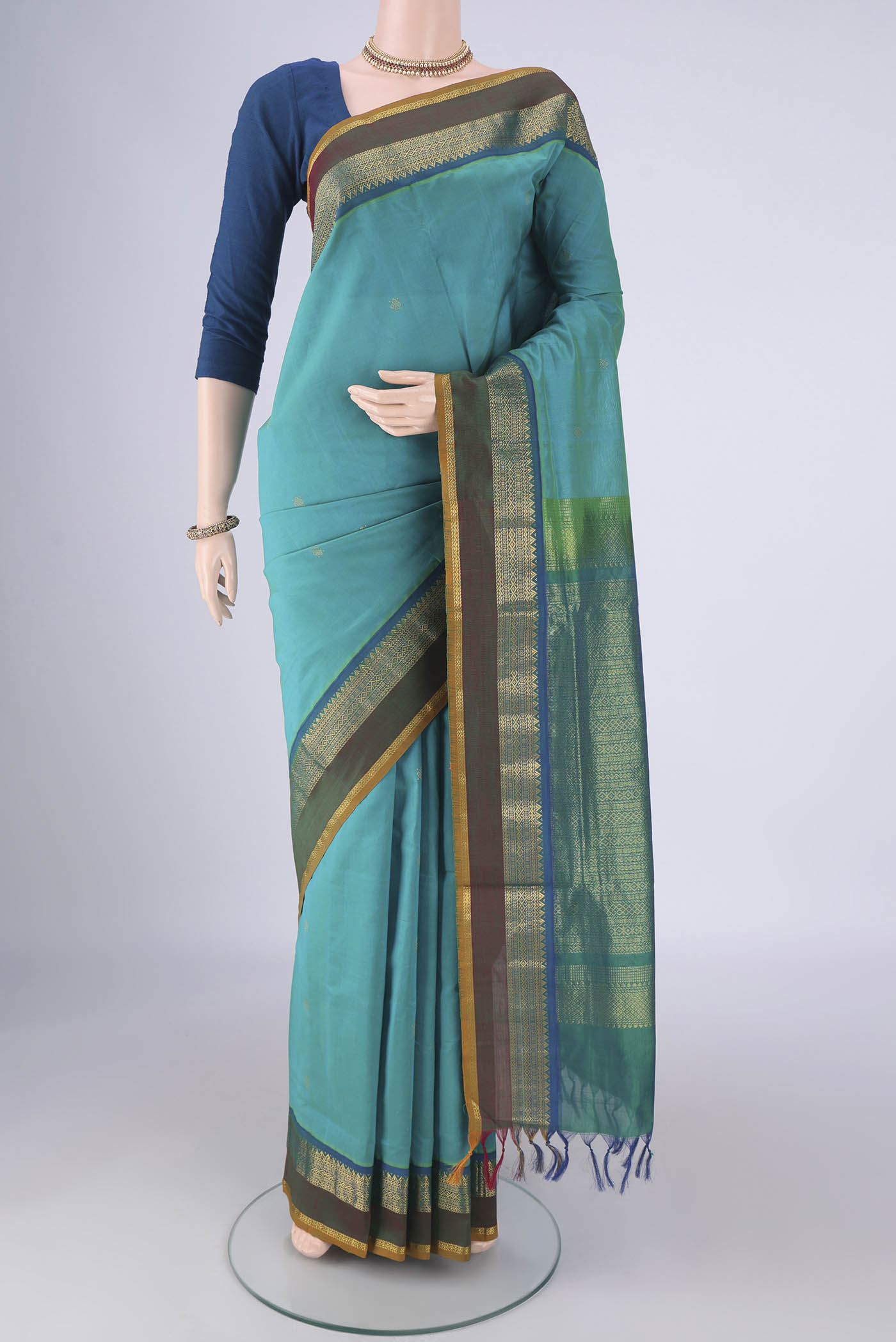 Sea Green Coimbatore Silk Cotton Saree with Zari Butta on the body and Zari Border.  displayed on a mannequin