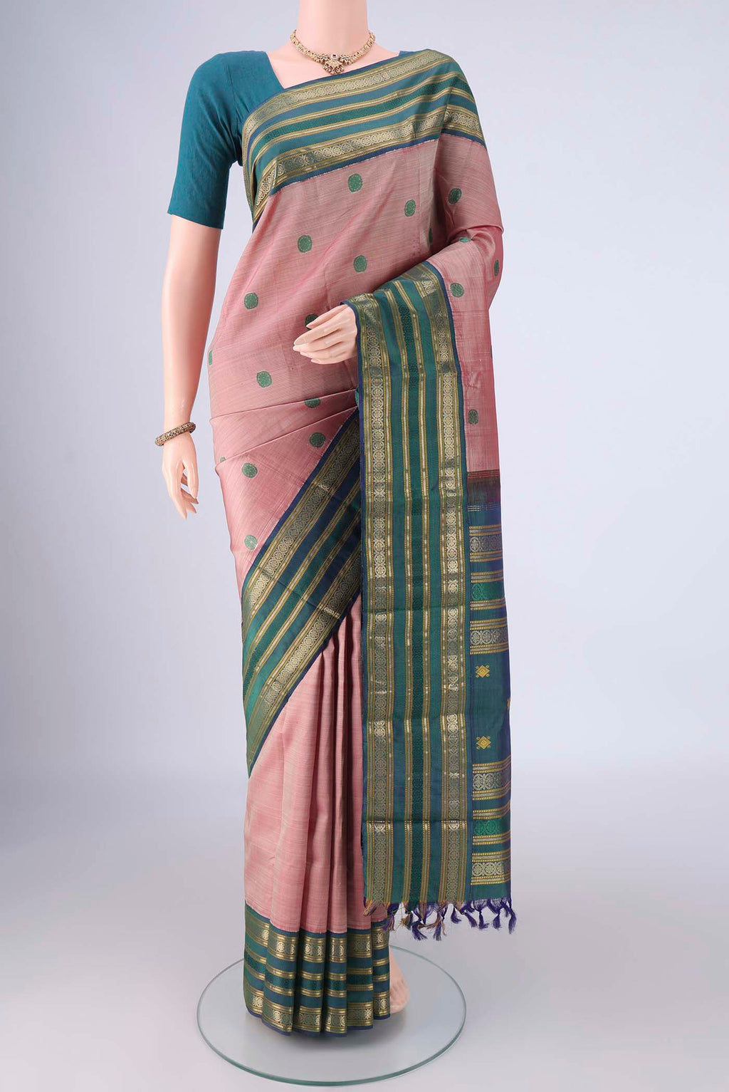 Rose Gold Kanjivaram Silk Saree with Thread Butta on the body and Zari Border.  displayed on a mannequin