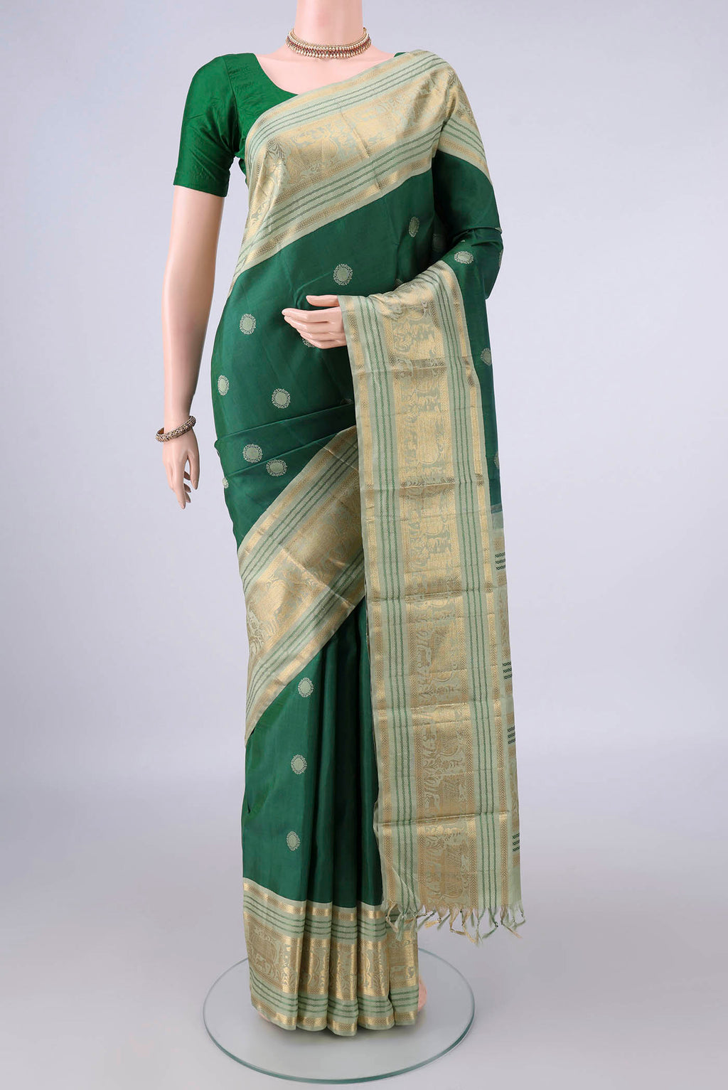 Pure Silk Green Kanchipuram Saree with Thread Butta on the body and Zari And Thread Border.  displayed on a mannequin