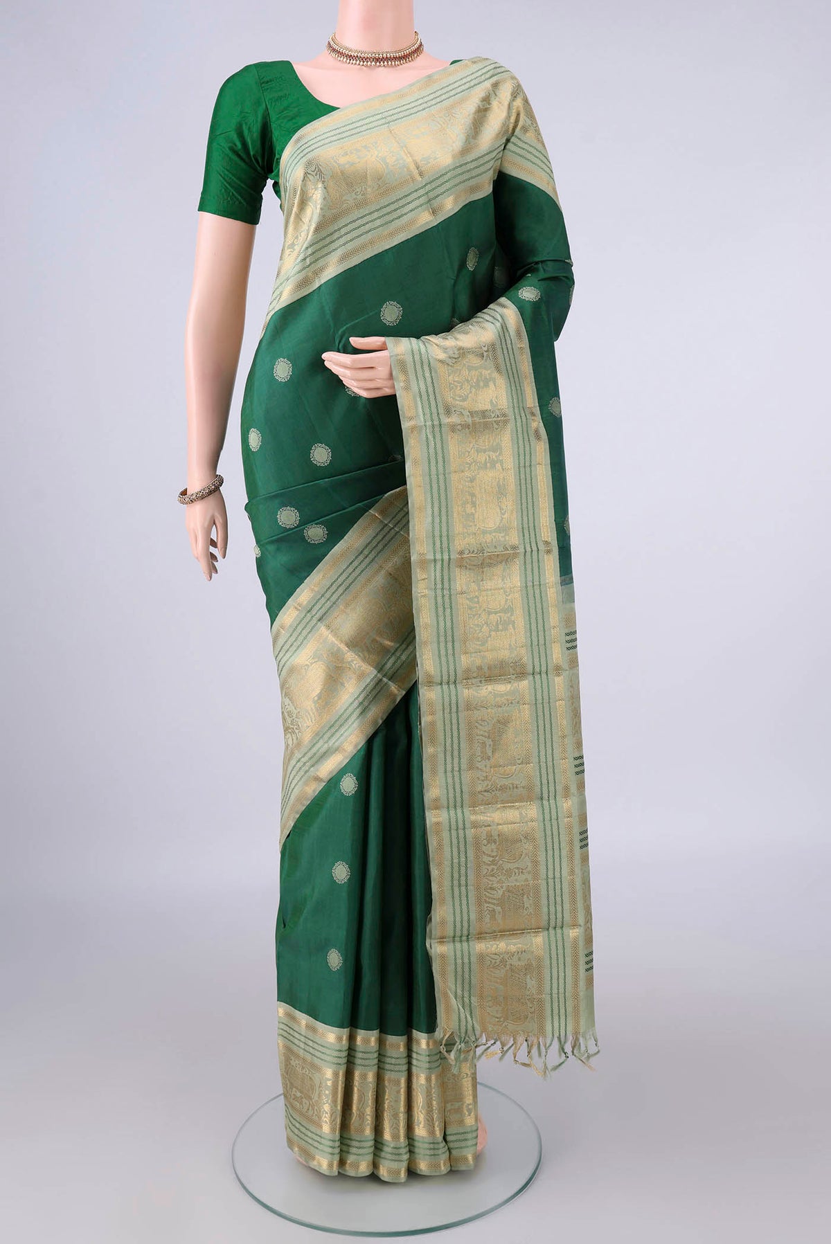 Pure Silk Green Kanchipuram Saree with Thread Butta on the body and Zari And Thread Border.  displayed on a mannequin