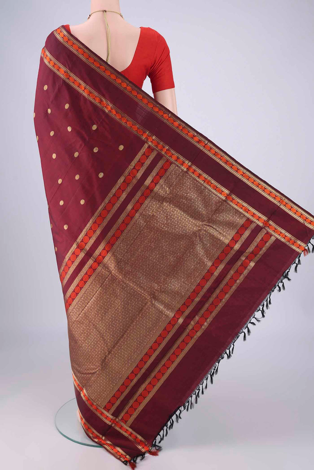 Flat view of Maroon Kanjivaram Silk Saree with Zari Butta on the body and Zari And Thread Border. 