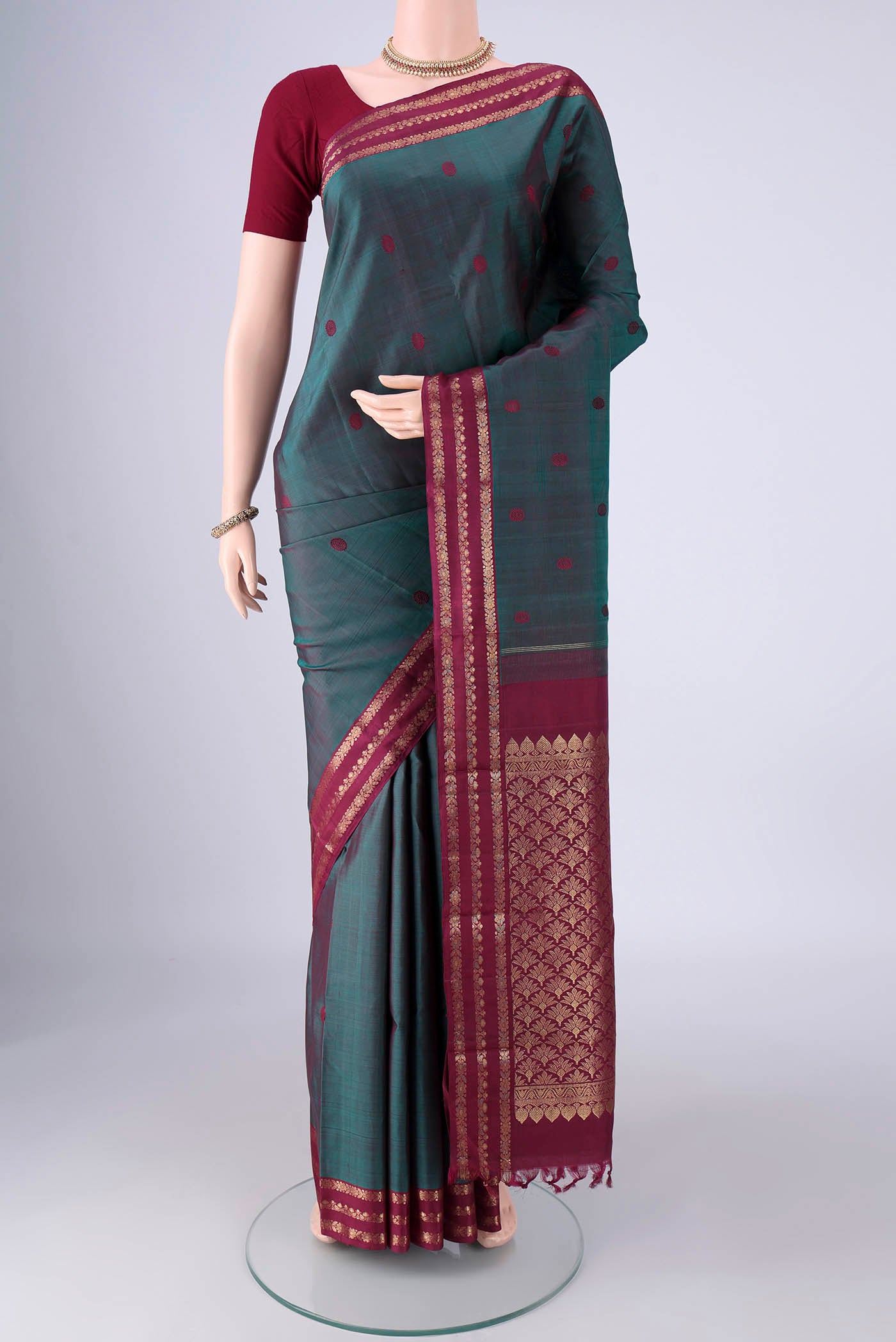 Peacock Blue Dual Tone Kanjivaram Silk Saree with Thread Butta on the body and Zari Border.  displayed on a mannequin