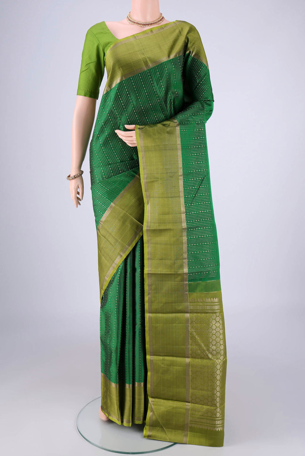 Bottle Green Kanchipuram Silk Saree with Stripes on the body and Zari Border.  displayed on a mannequin