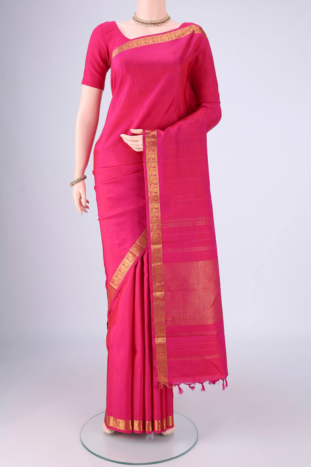 Rani Pink Kanjivaram Silk Saree with Plain Body and Zari Border.  displayed on a mannequin