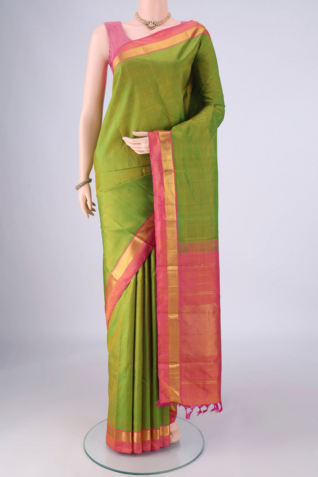 Green Kanjivaram Silk Saree with Plain Body and Zari Border.  displayed on a mannequin