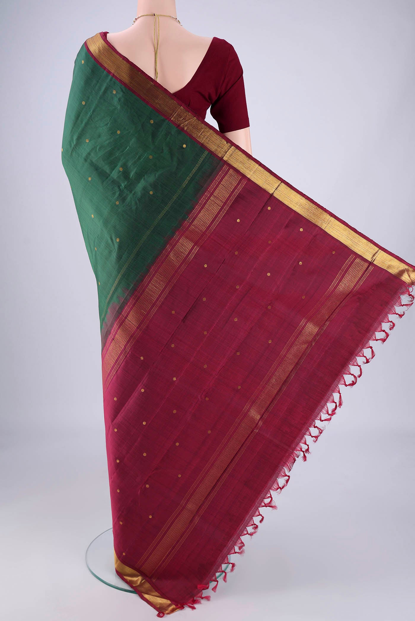 Flat view of Bottle Green Kanjivaram Silk Saree with Zari Butta on the body and Zari Border. 