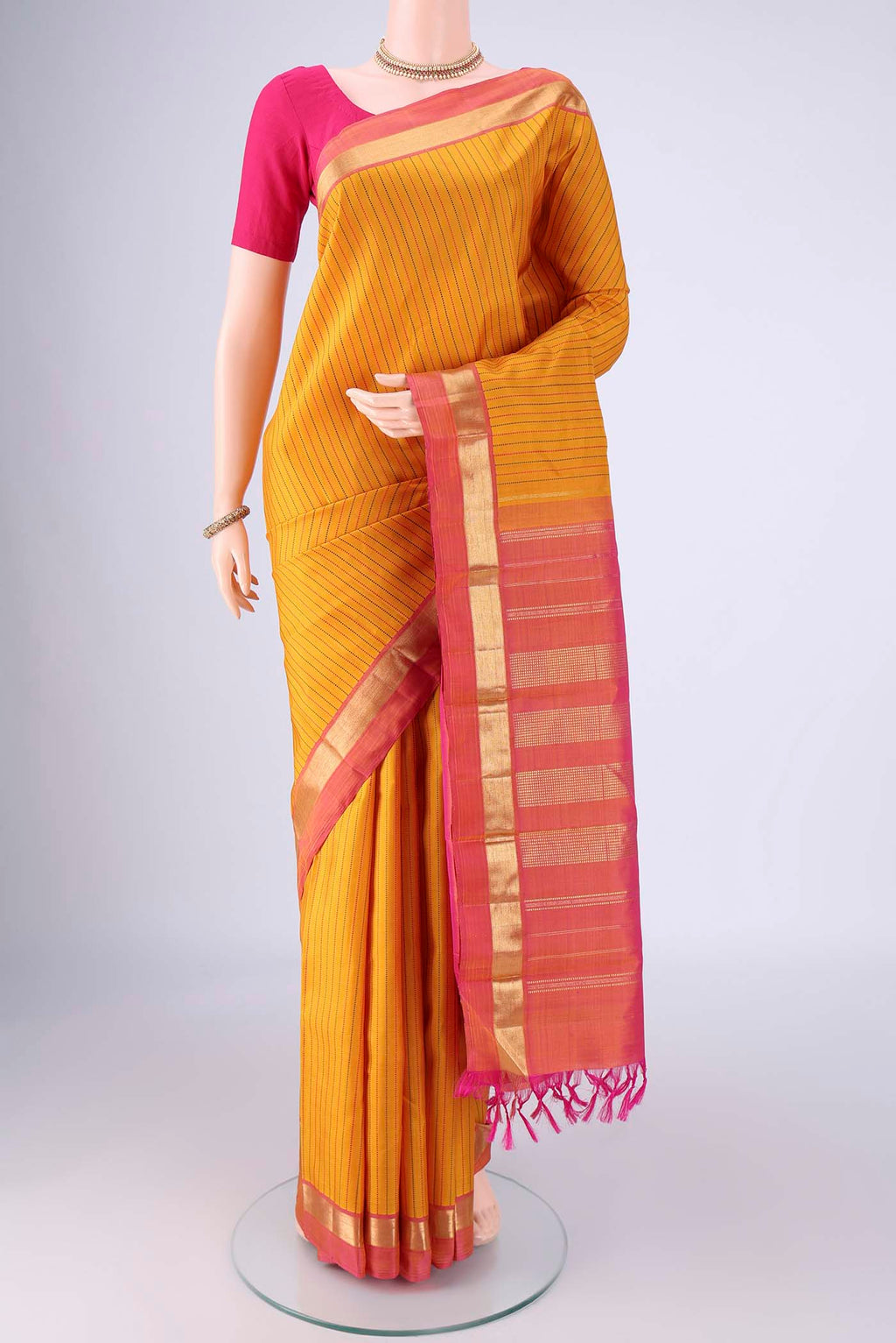 Yellow Kanchipuram Silk Saree with Stripes on the body and Zari Border.  displayed on a mannequin