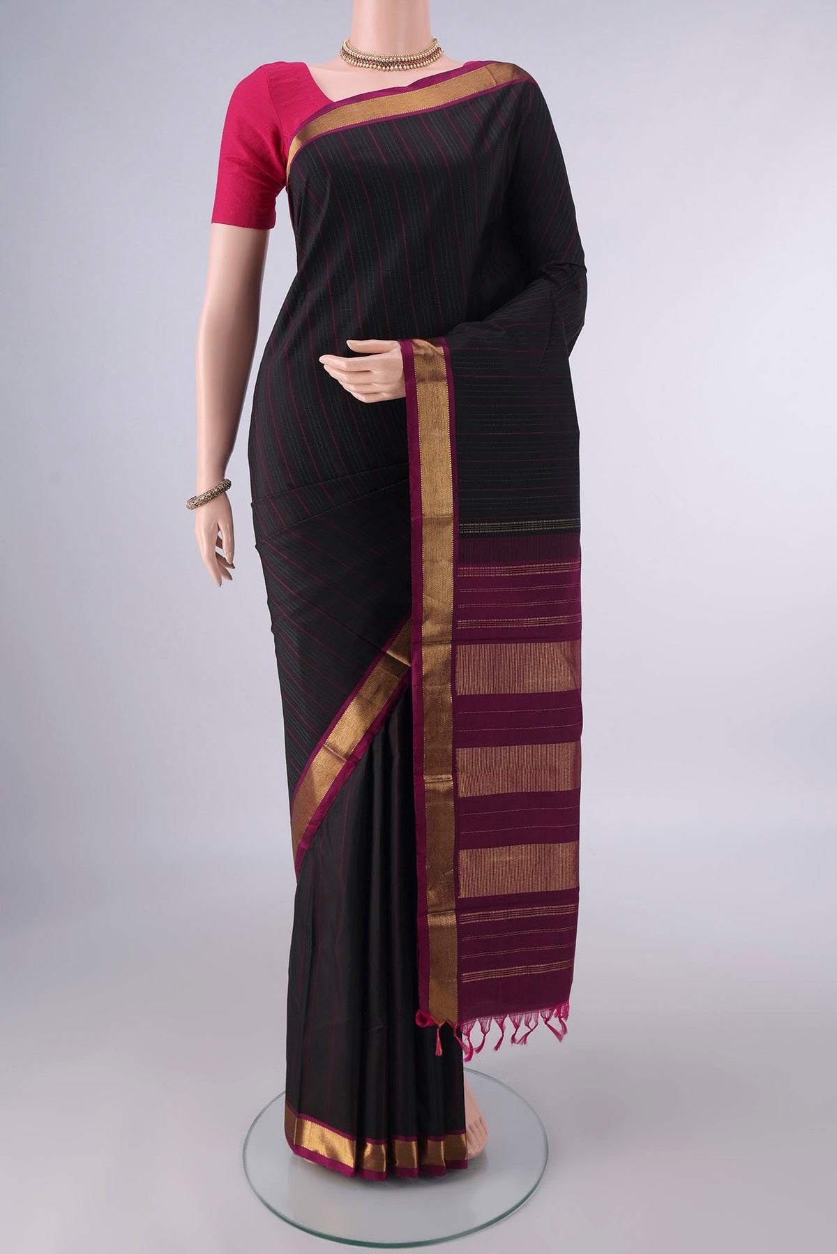 Pure Silk Black Kanchipuram Saree with Stripes on the body and Zari Border.  displayed on a mannequin