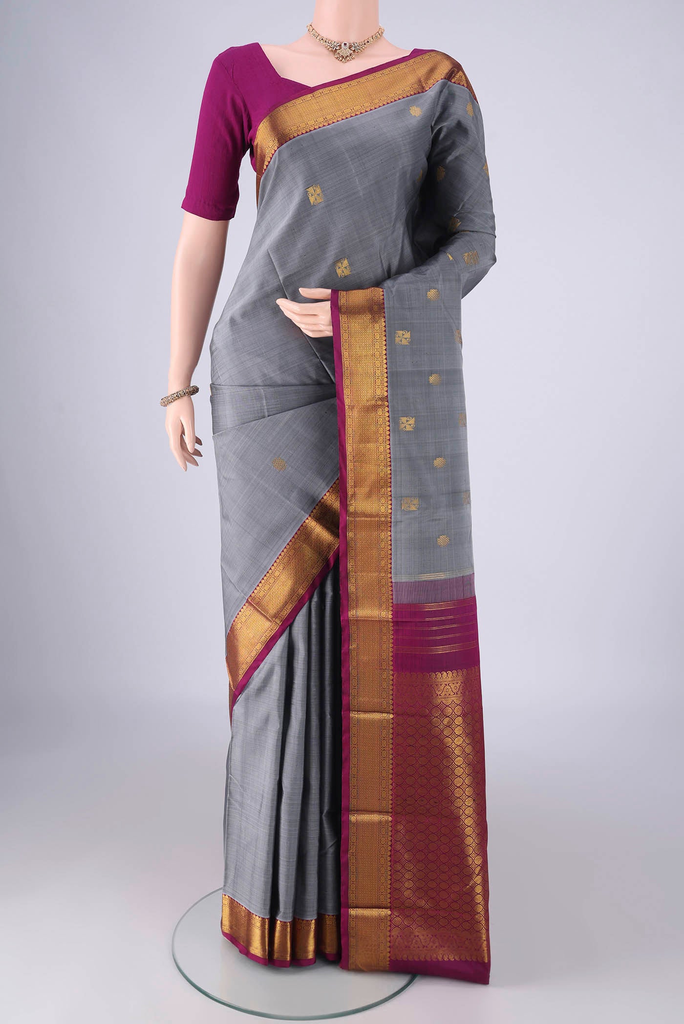 Grey Kanchipuram Silk Saree with Zari Butta on the body and Zari Border.  displayed on a mannequin