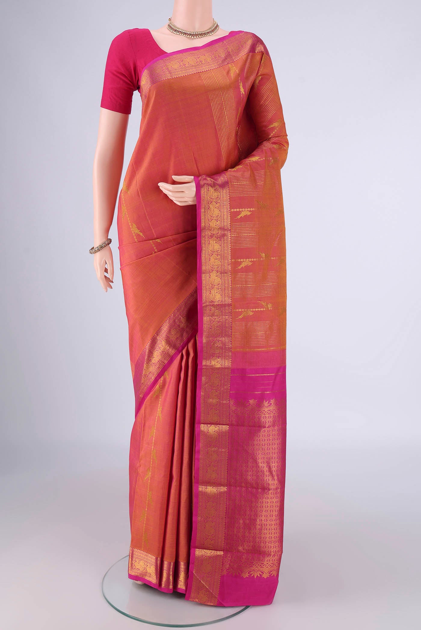 Brick Orange Dual Tone Kanjivaram Silk Saree with Stripes on the body and Zari Border.  displayed on a mannequin