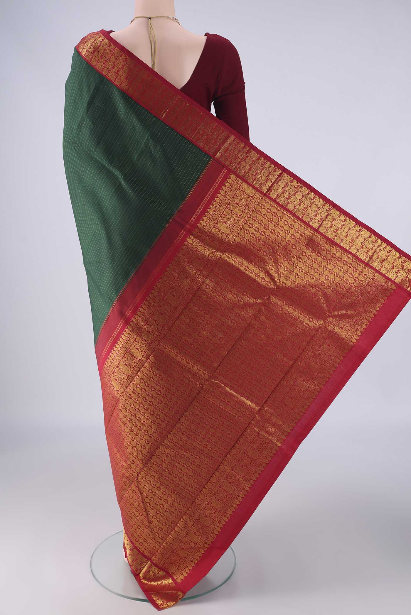 Flat view of Bottle Green Kanjivaram Silk Saree with Stripes on the body and Zari Border. 